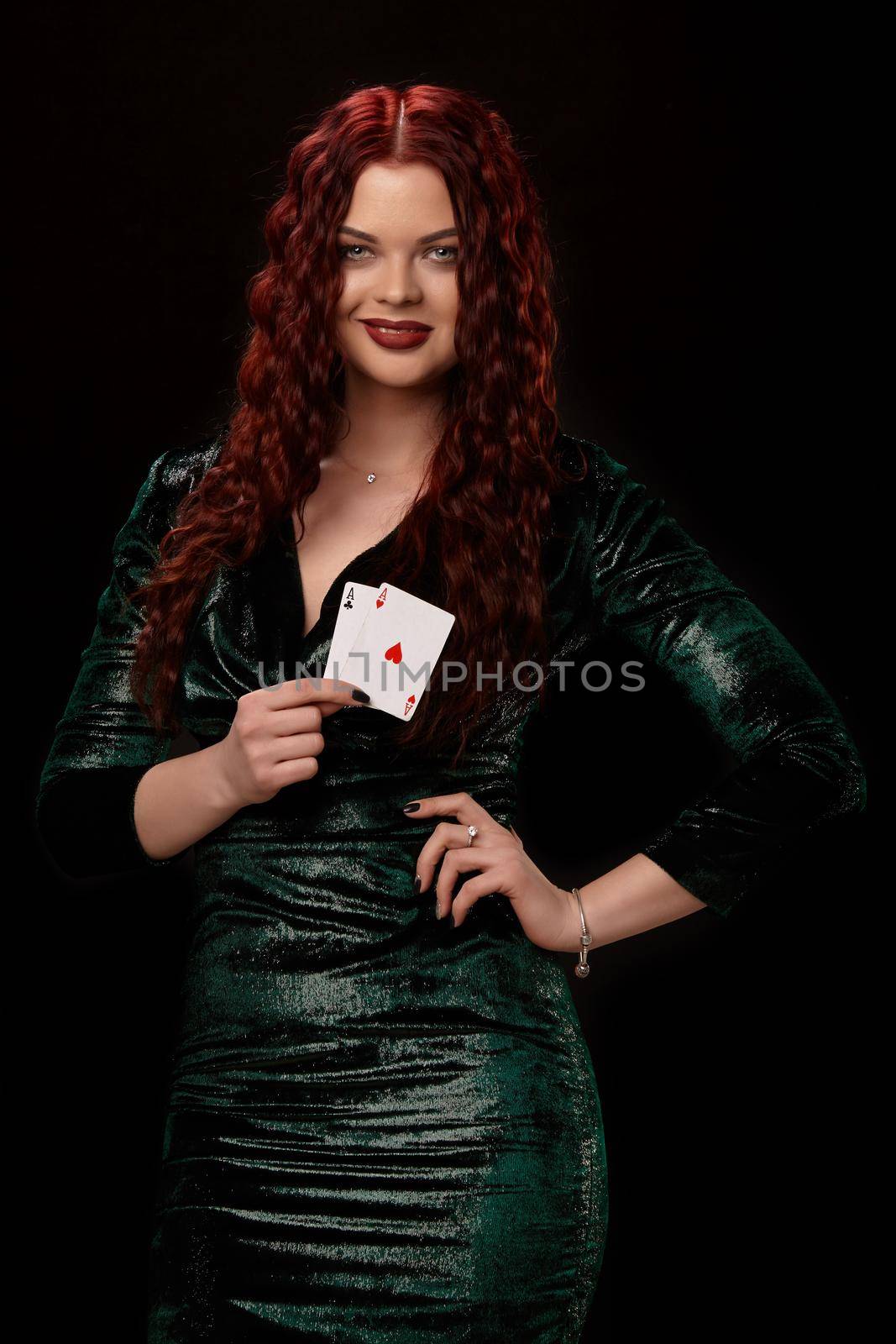 Sexy redheaded woman posing with a playing cards in her hands, on black background by nazarovsergey