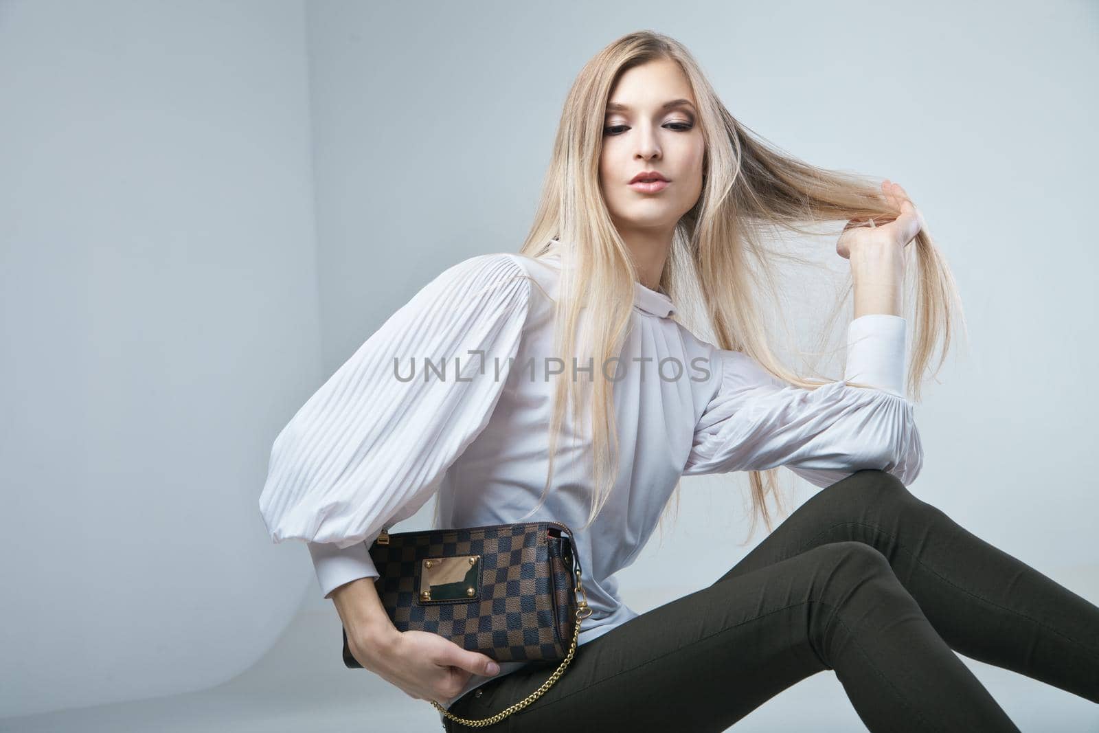 Full length casual young fashionable woman with a bag in light background