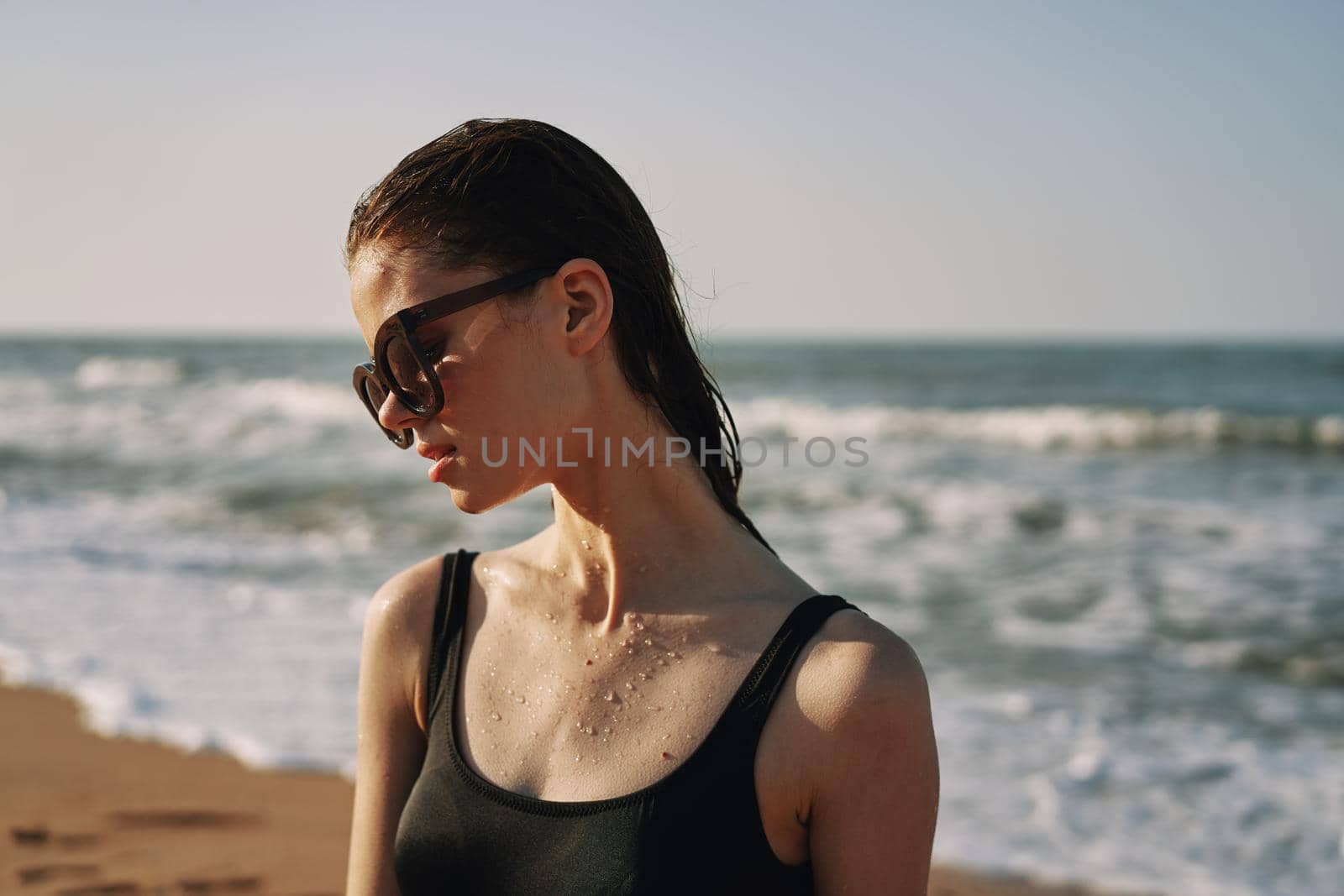 Cheerful woman black swimsuit ocean nature summer tan. High quality photo