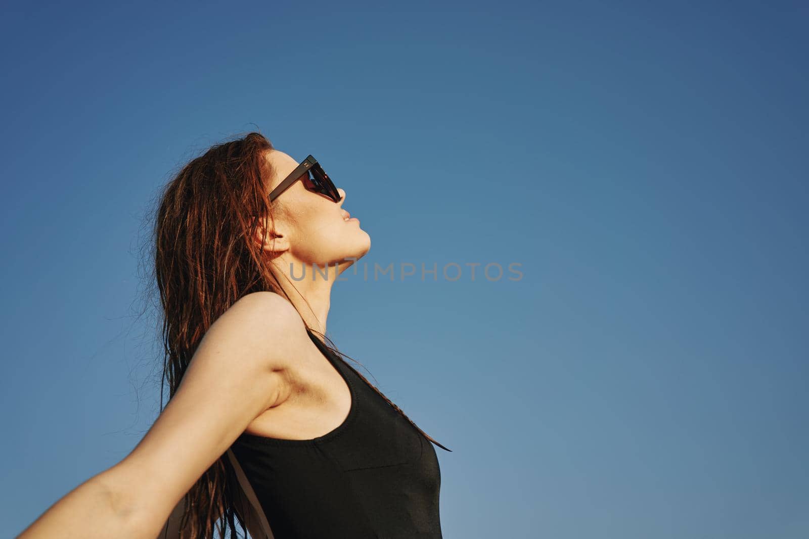 woman in black swimsuit sunglasses sun nature. High quality photo