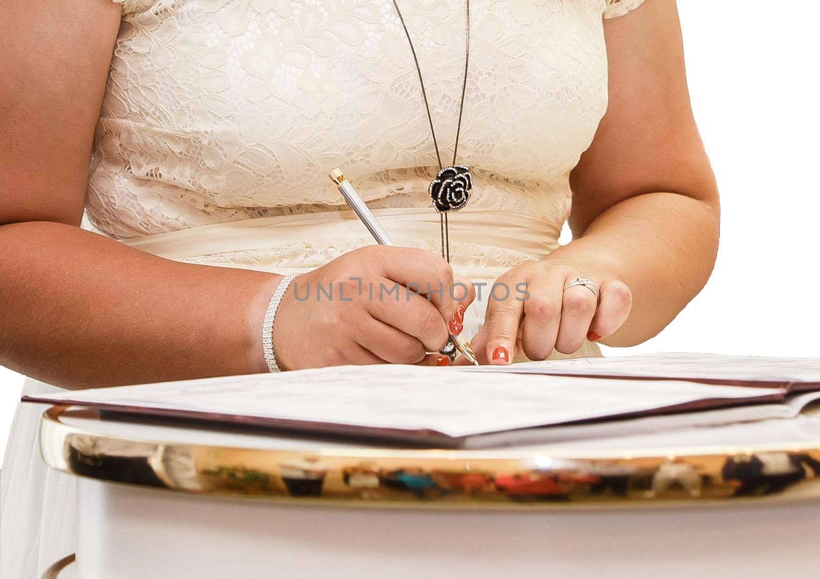 The girl's hands at the wedding put their signature pen in the magazine about marriage registration.