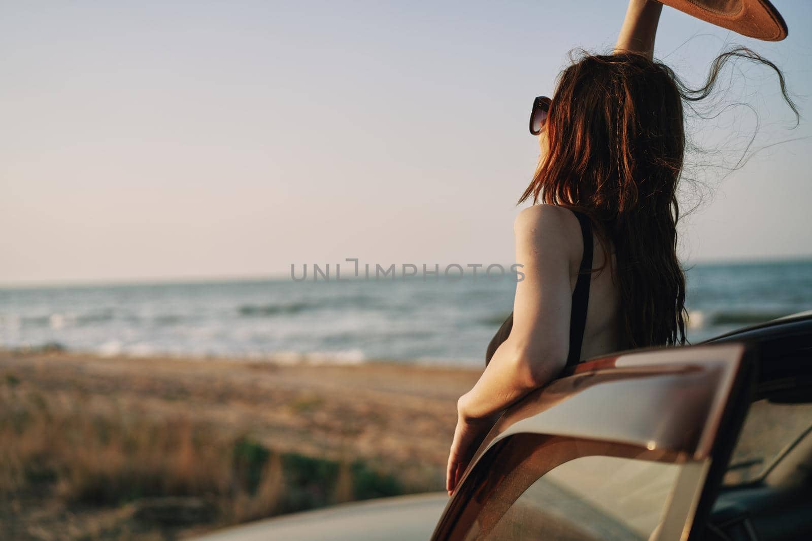pretty woman in sunglasses near the car on the beach travel lifestyle. High quality photo