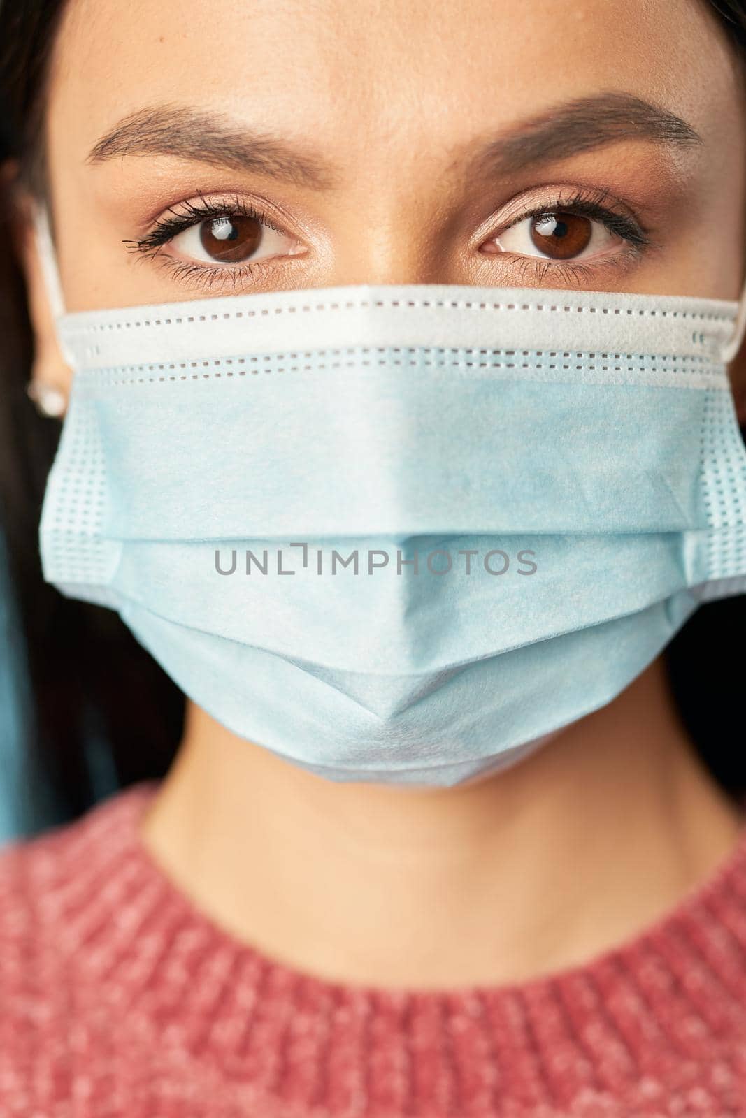 Close up of pretty young female posing and looking at camera while wearing protective face mask. Quarantine, coronavirus concept