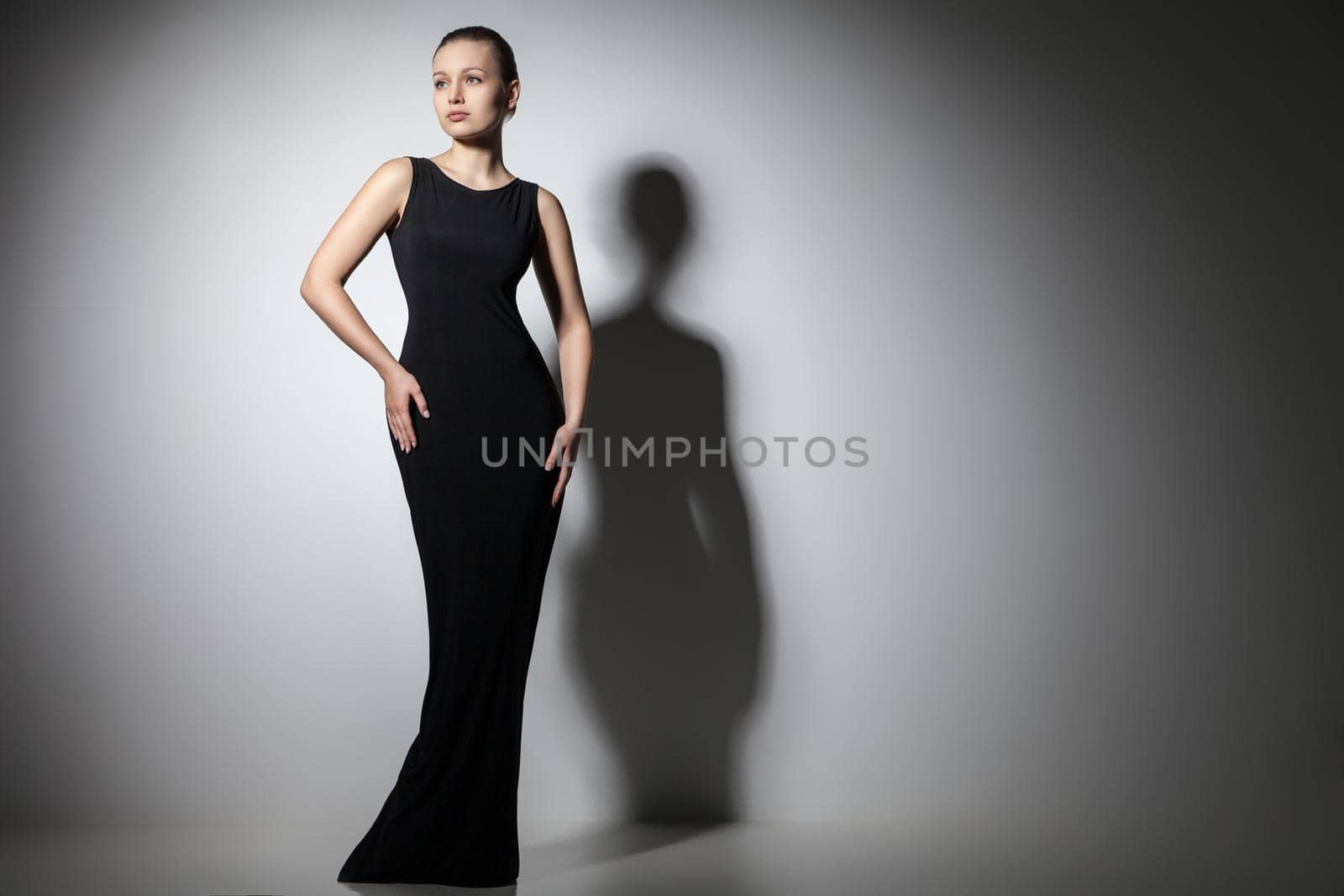 beautiful woman model posing in elegant black dress in the studio