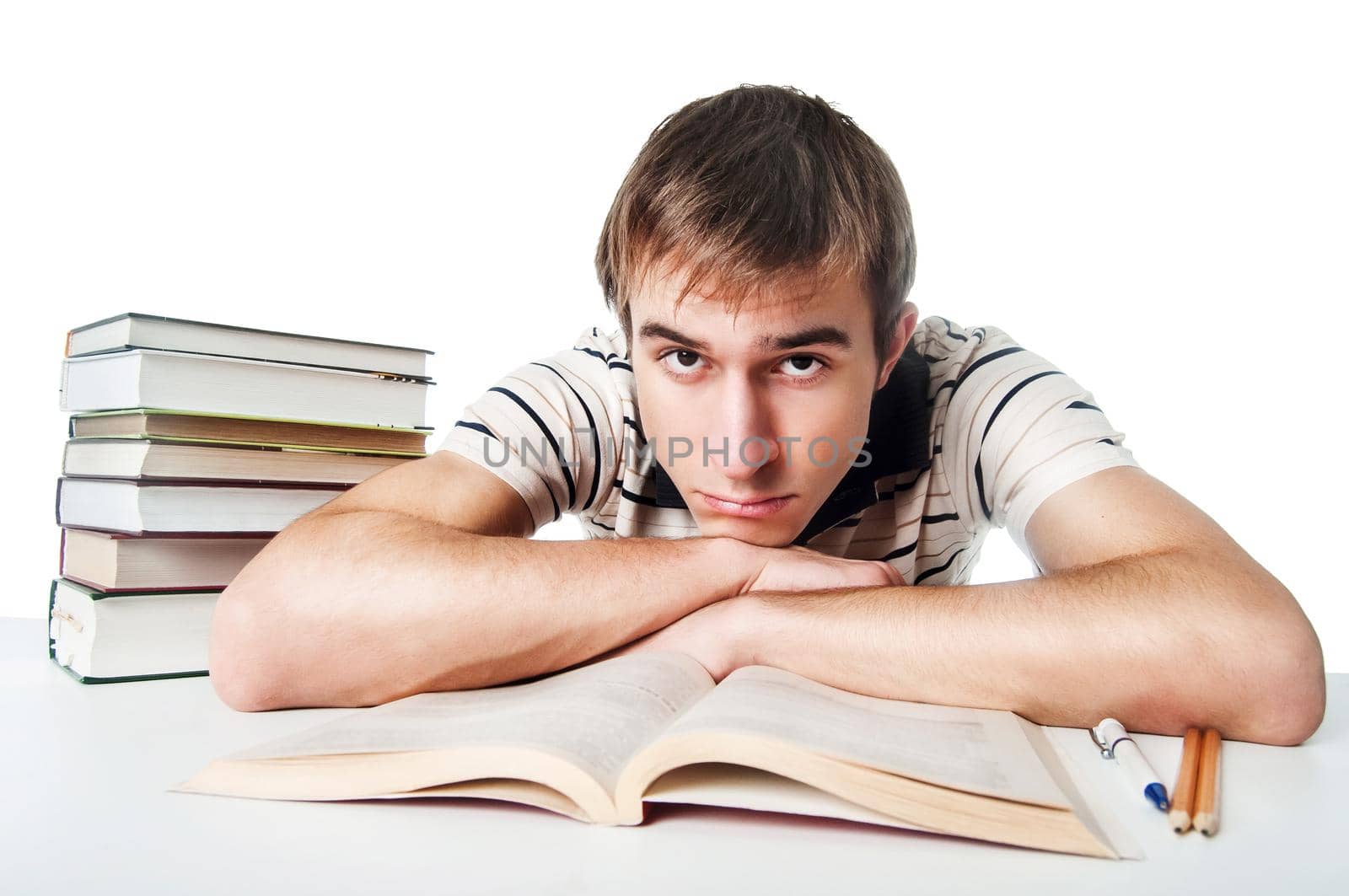 Male student at the table with a pile of books over white