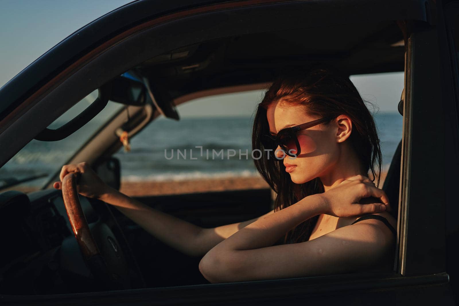 cheerful woman in sunglasses driving a car trip travel. High quality photo