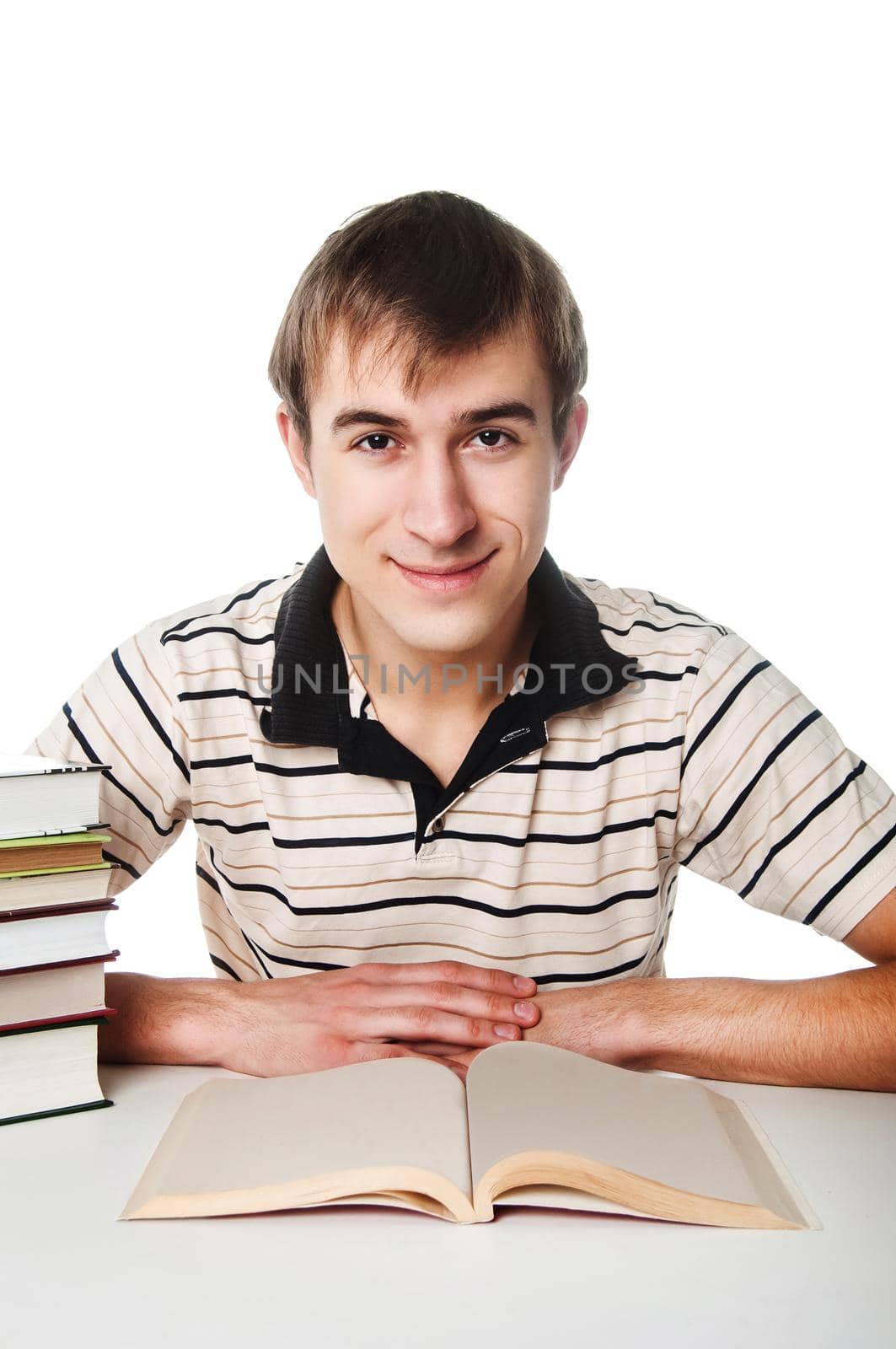 Male student at the table with a pile of books over white