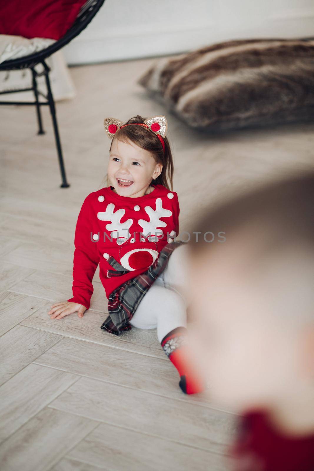 Lovely little girl in red dress with Christmas present. by StudioLucky