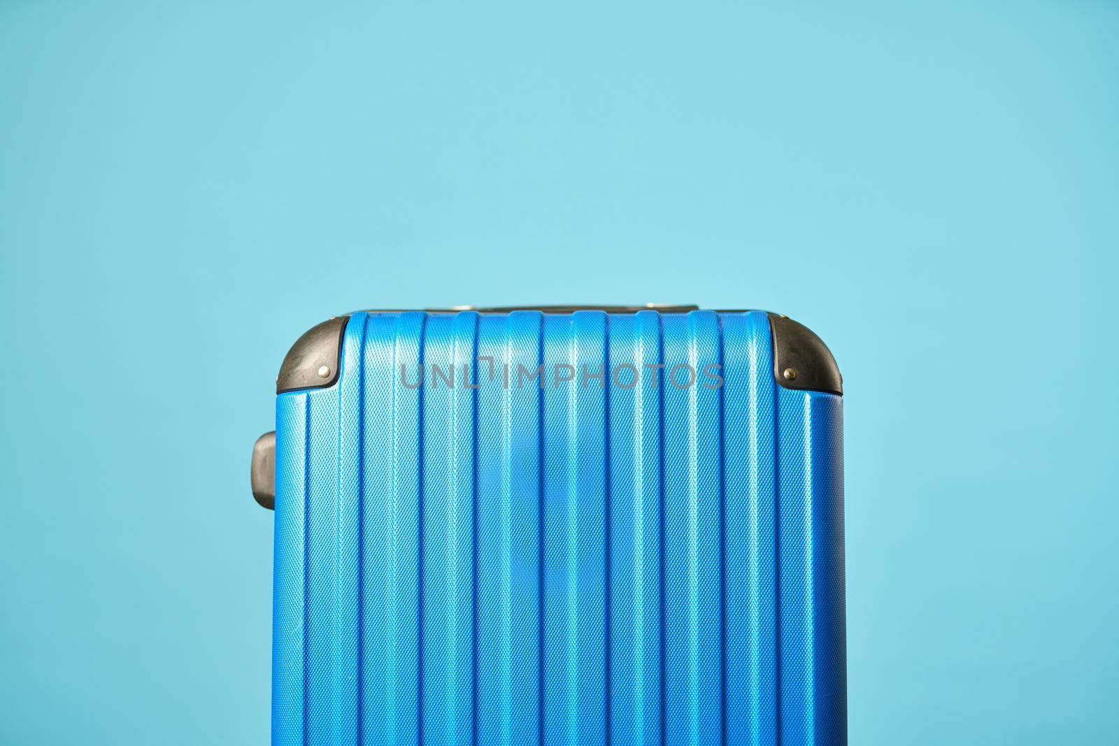 Close up of blue suitcases, isolated on blue background. Copy space. Concept of travel