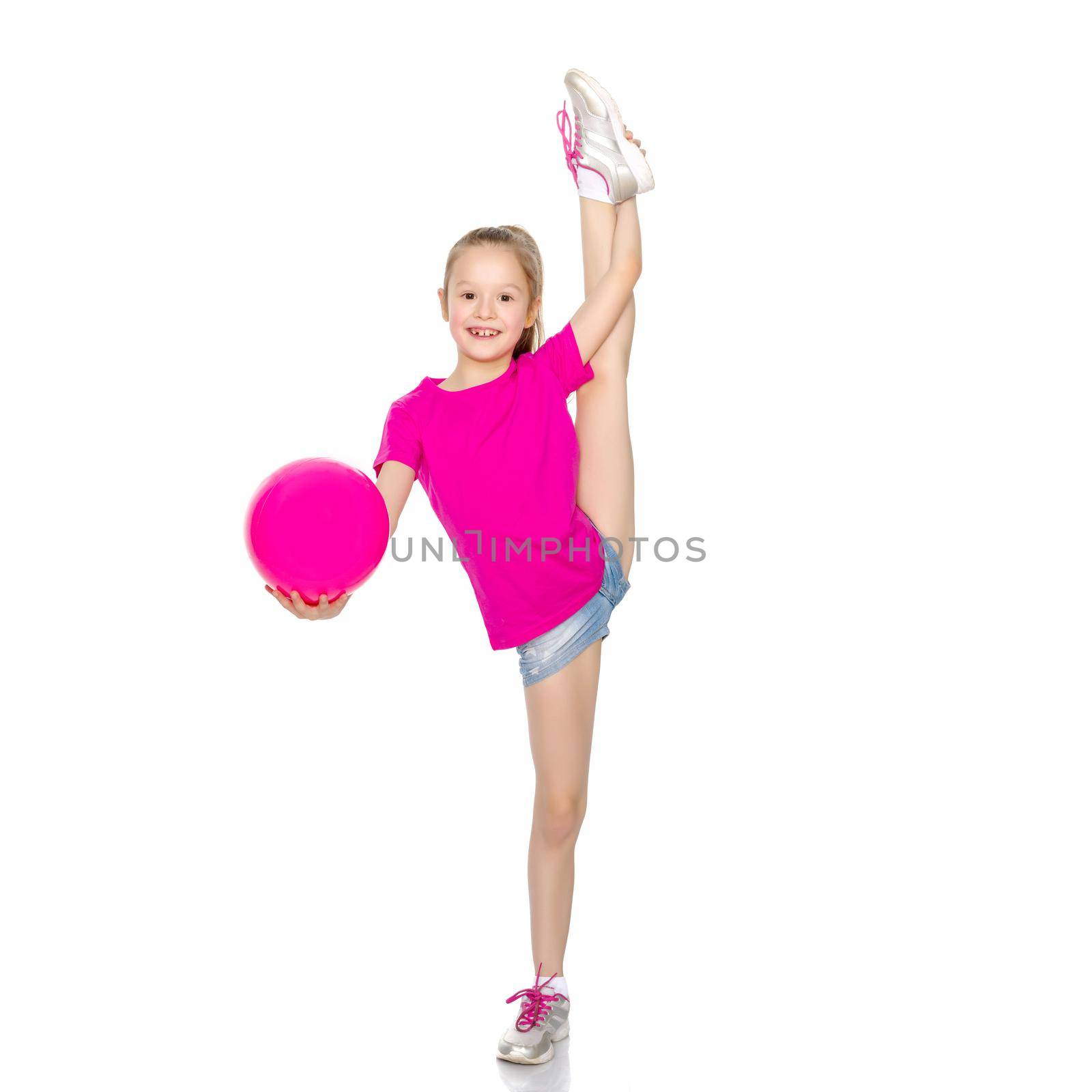 A charming little girl is engaged in fitness with a ball. The concept of gymnastics, health and sports. Isolated on white background.