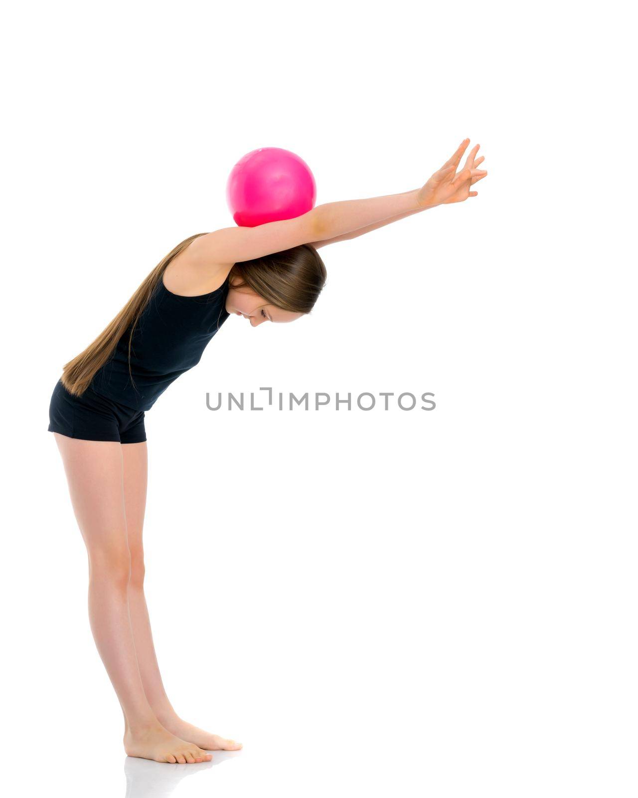 A charming little girl is engaged in fitness with a ball. The concept of gymnastics, health and sports. Isolated on white background.