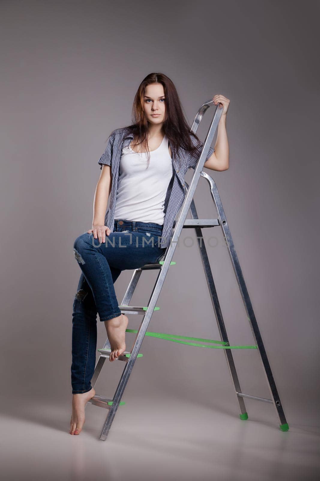 Young woman on step ladder. by Julenochek