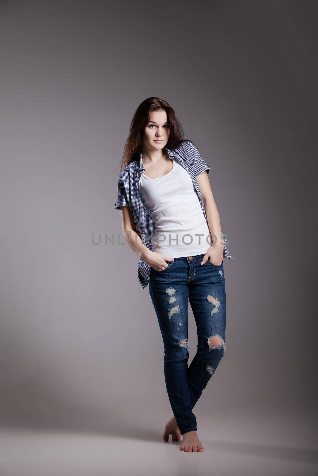 Full length portrait of an attractive girl in casual jeans clothes possing at studio