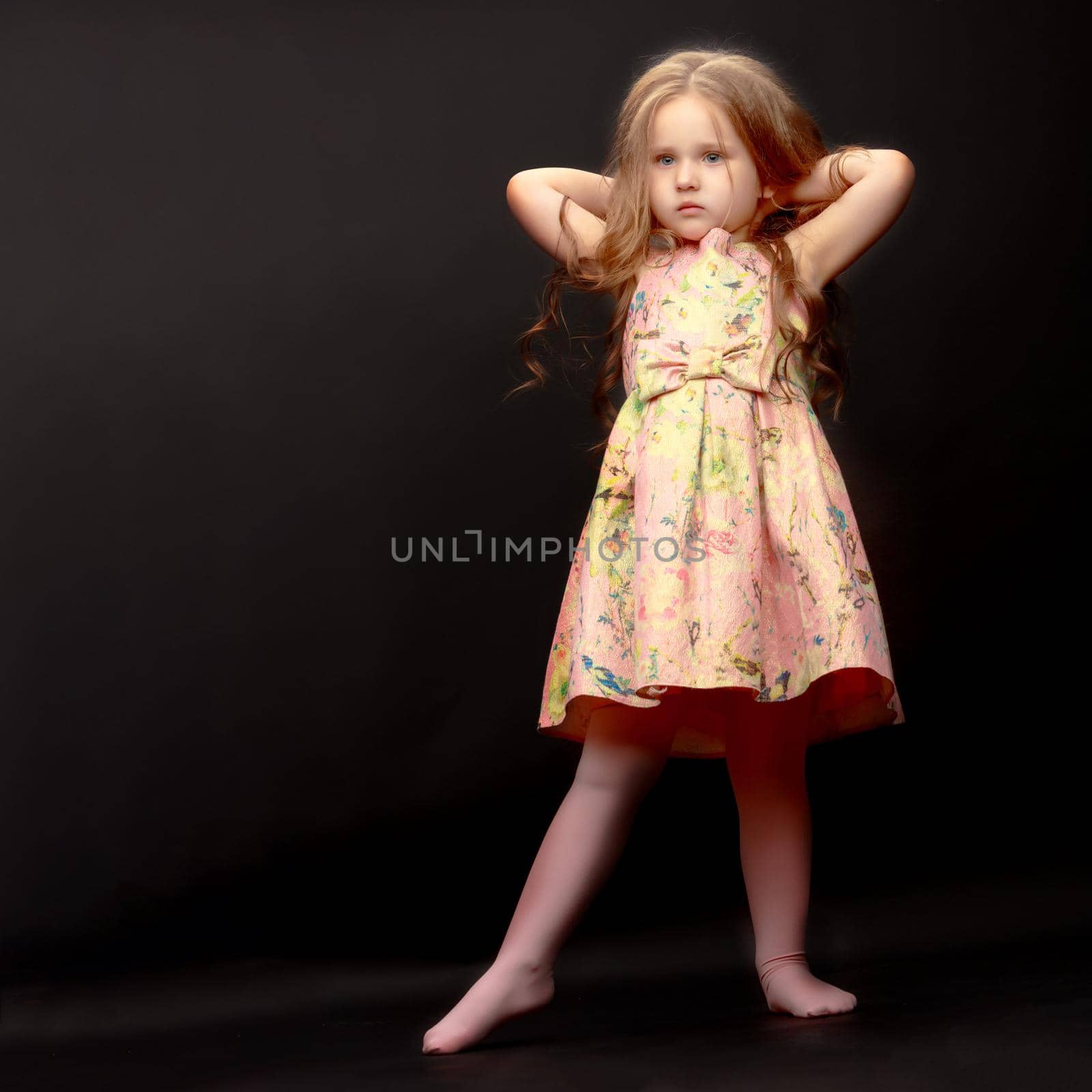 Beautiful little girl on a black background. Studio photography