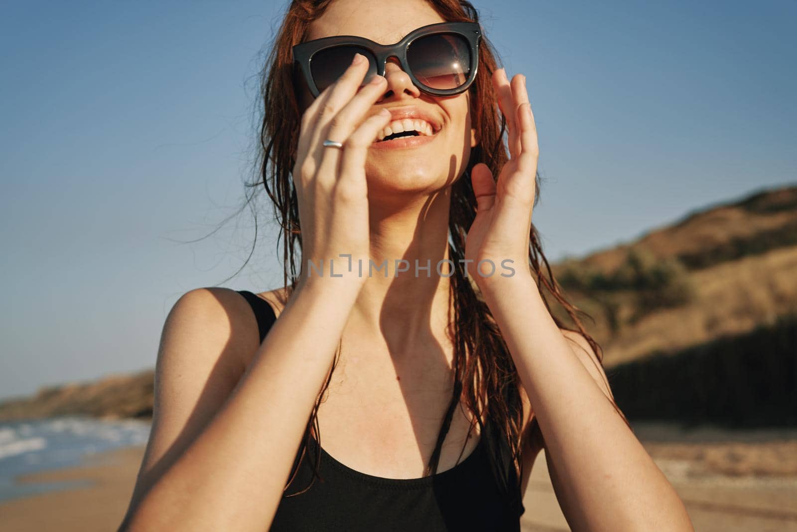 cheerful woman in sunglasses in a swimsuit on the beach sun island. High quality photo