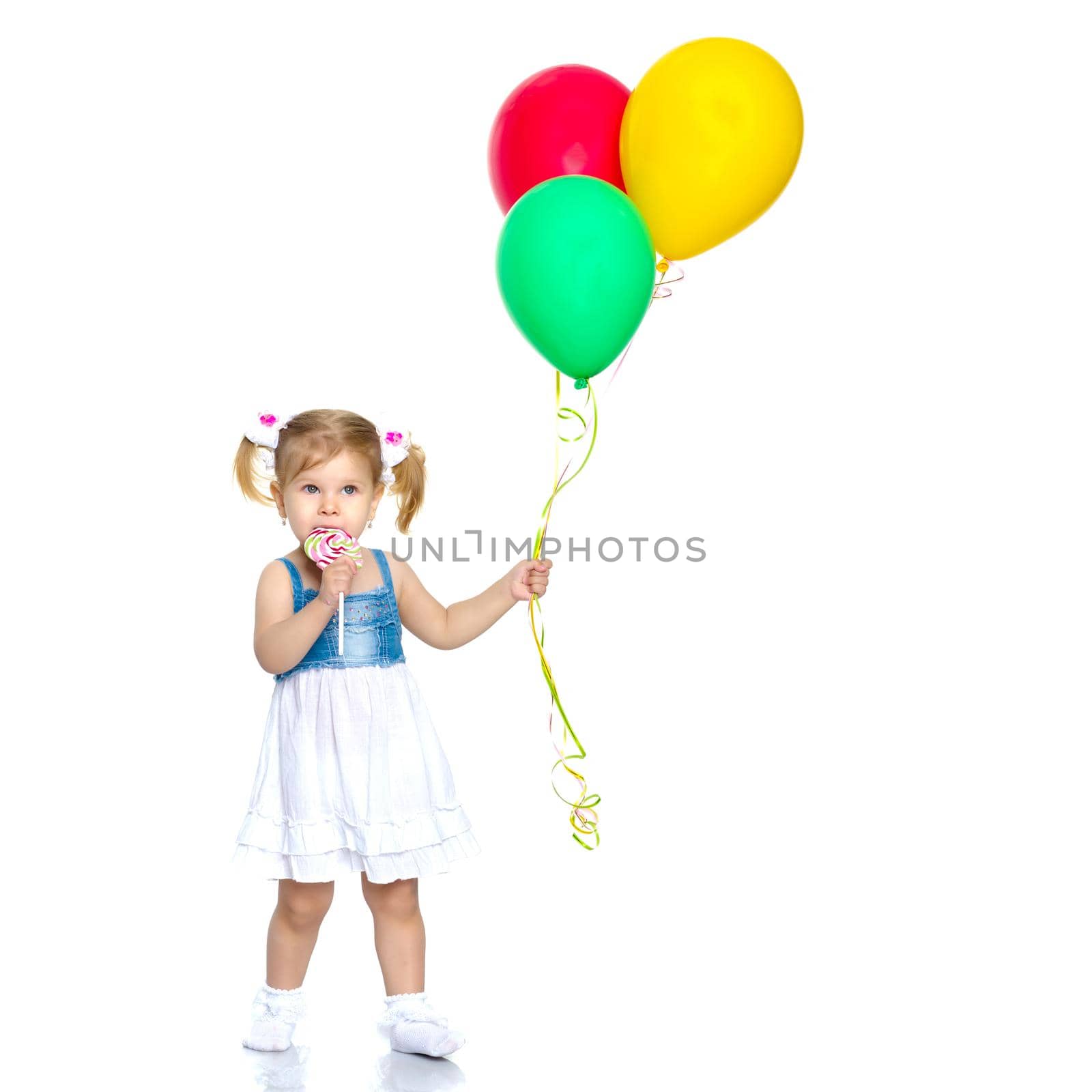 Little girl is playing with a balloon. The concept of the holiday, birthday. Isolated over white background