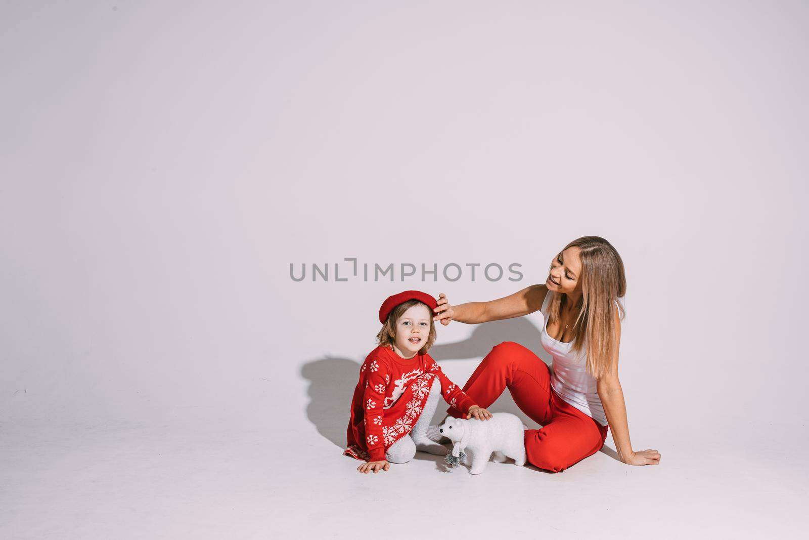 Beautiful young woman patting cute child on her head by StudioLucky