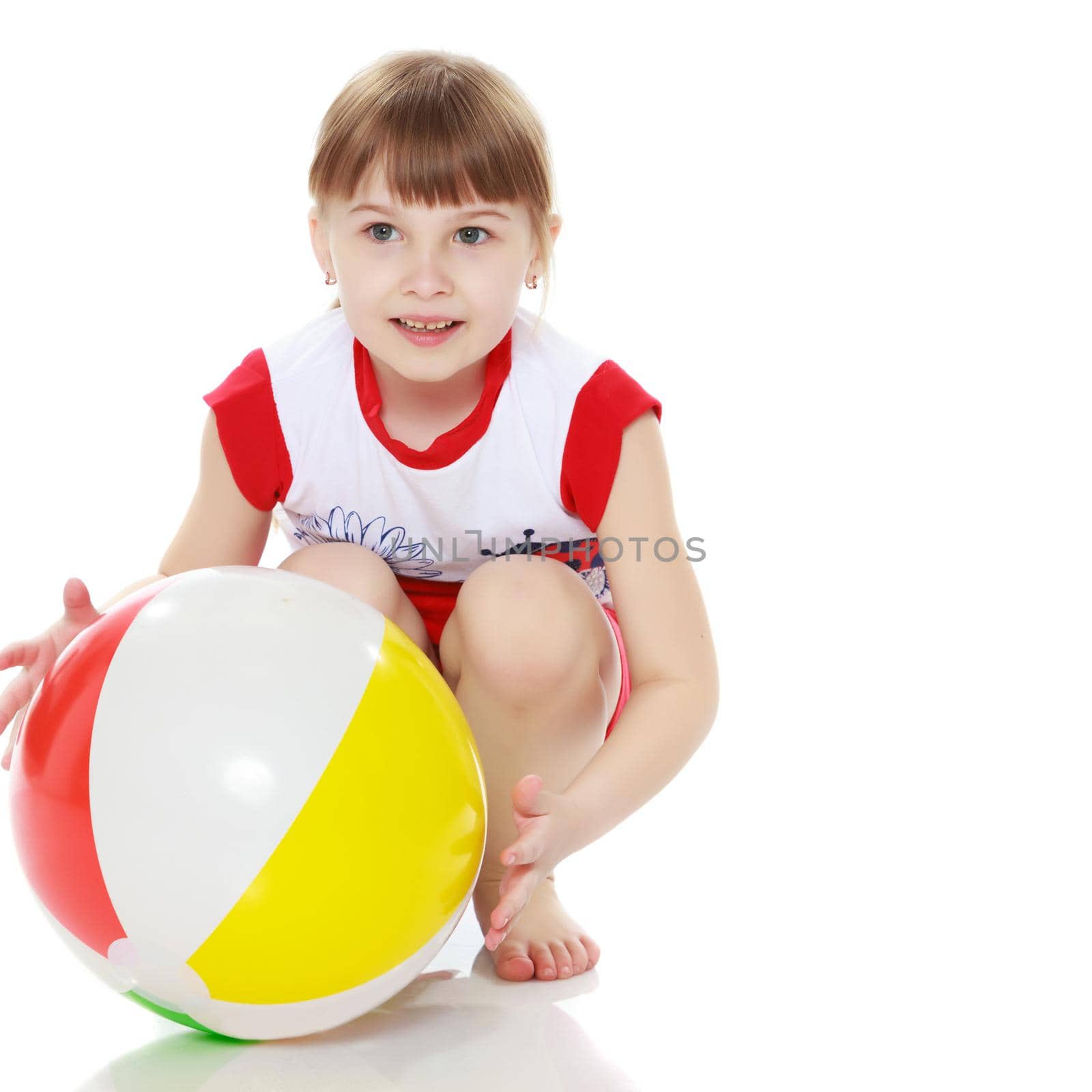 A nice little girl is playing with a big inflatable ball. The concept of a happy childhood, family recreation in nature, fitness and exercise. Isolated on white background.