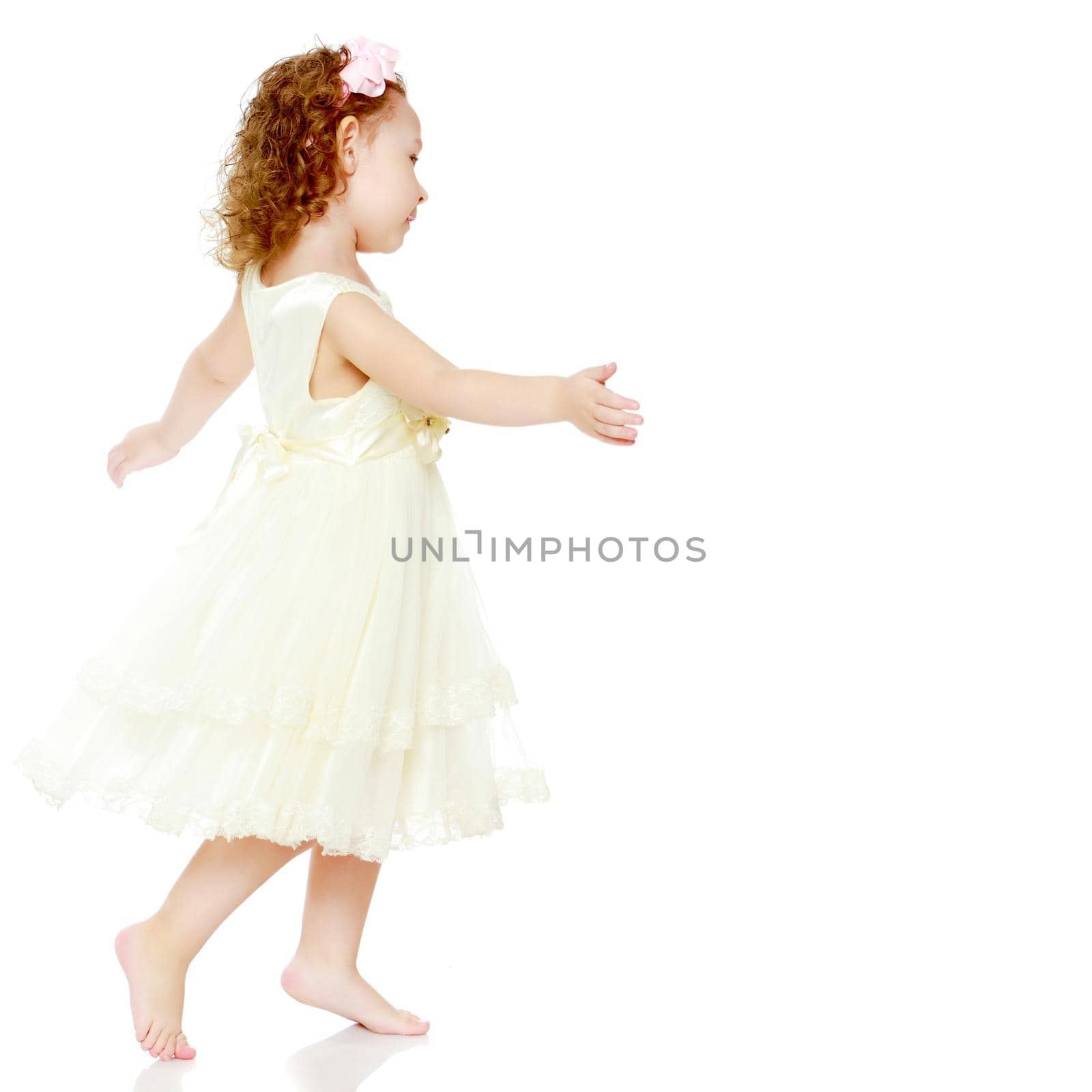 A little girl is jumping and waving her hands. The concept of a happy childhood, outdoor recreation. Isolated on white background.