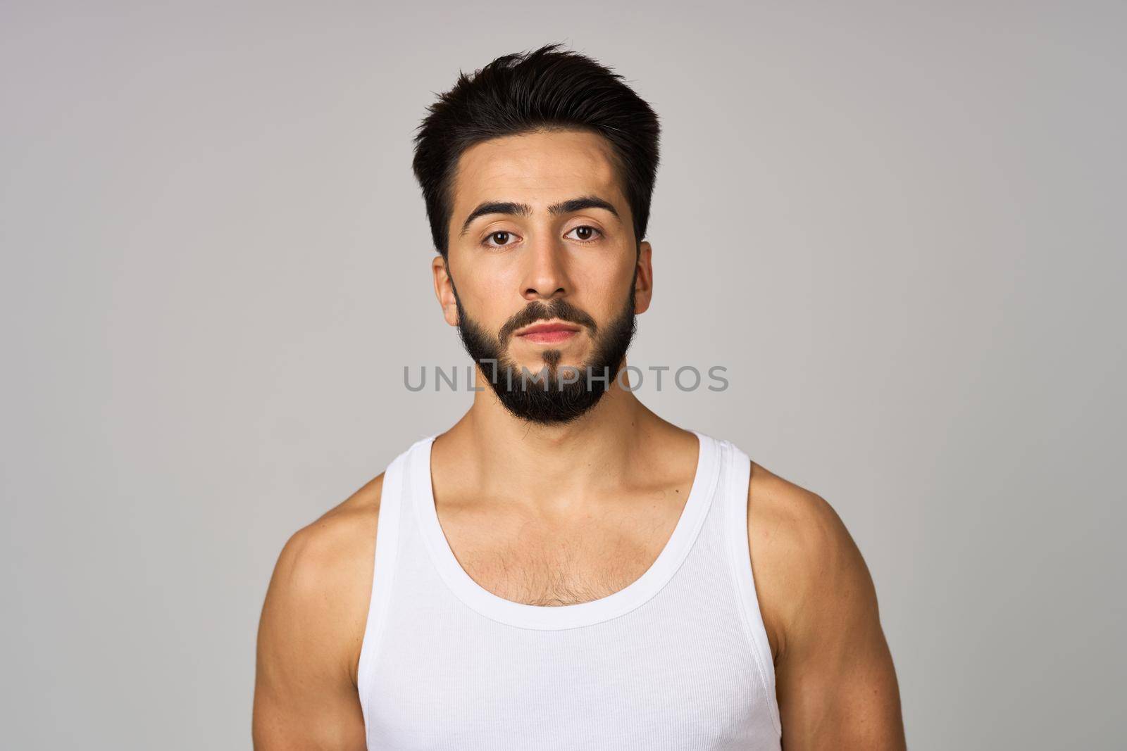cute bearded man in white studio tank top. High quality photo