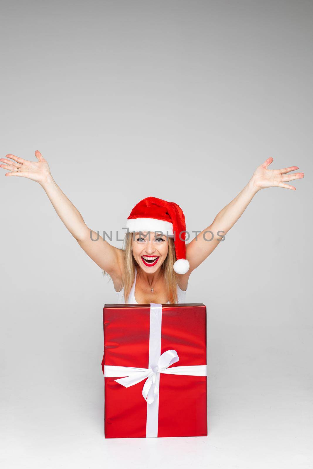 Happy woman bursting out of a fancy Christmas present by StudioLucky