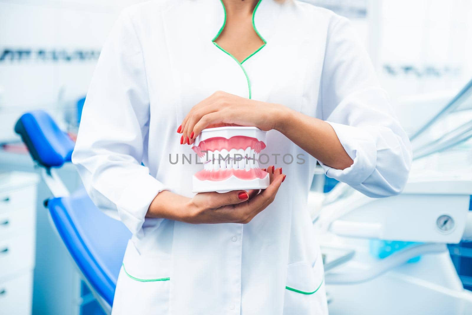 Nurse in uniform holding teeth model