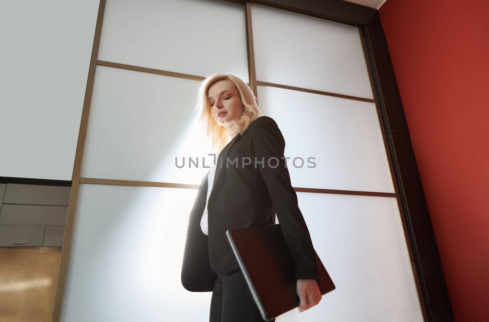 Young adult business woman wearing formalwear and carrying the laptop