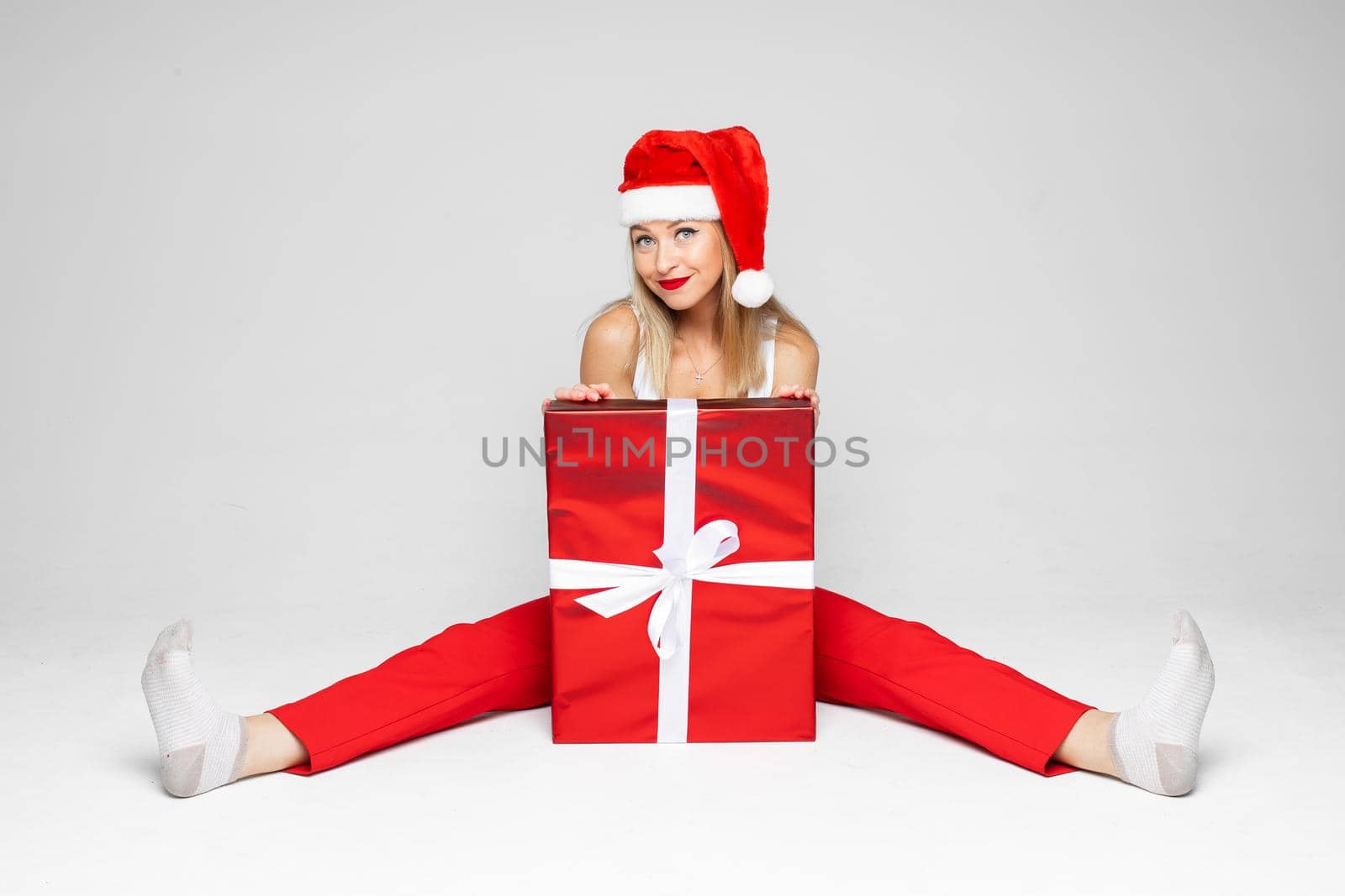 funny woman sits with a big red box, picture isolated on white background by StudioLucky