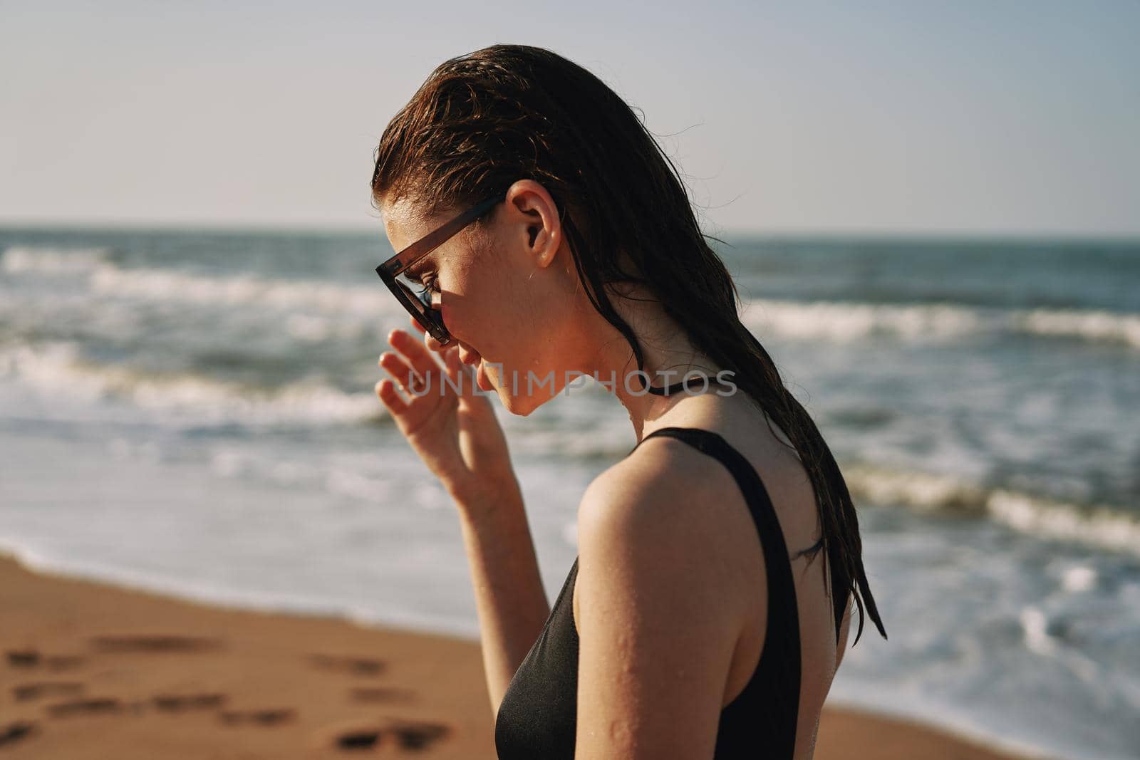 Cheerful woman black swimsuit ocean nature summer tan. High quality photo