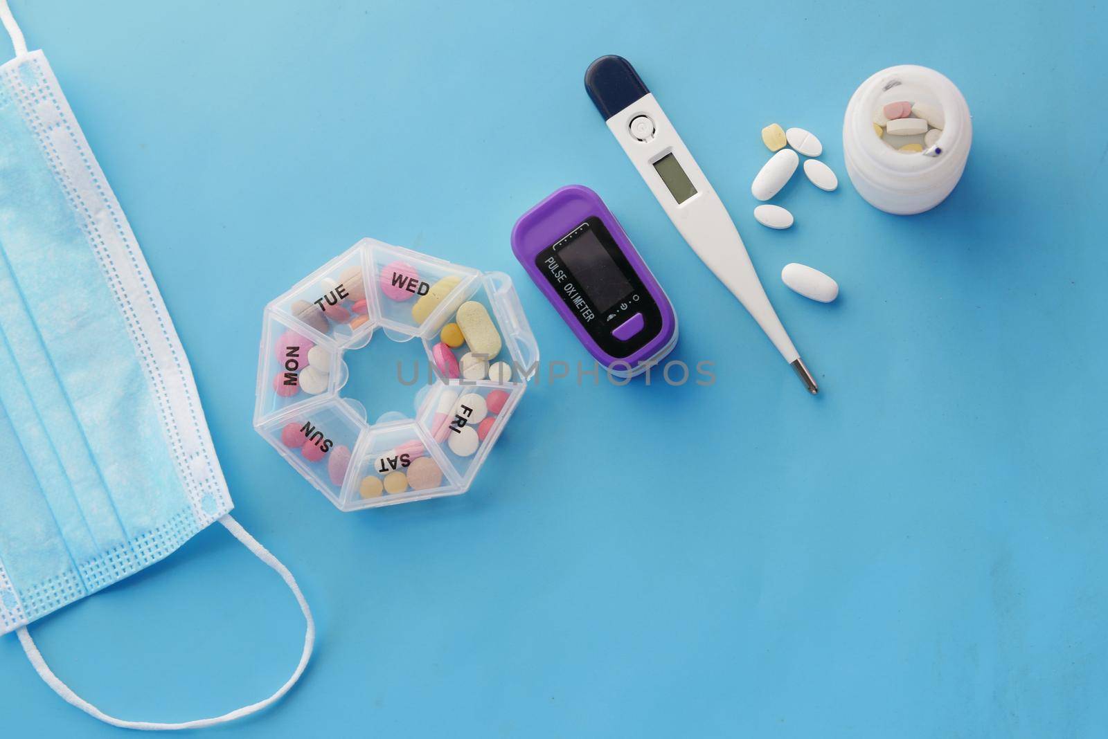 Surgical masks, thermometer and thermometer on blue .