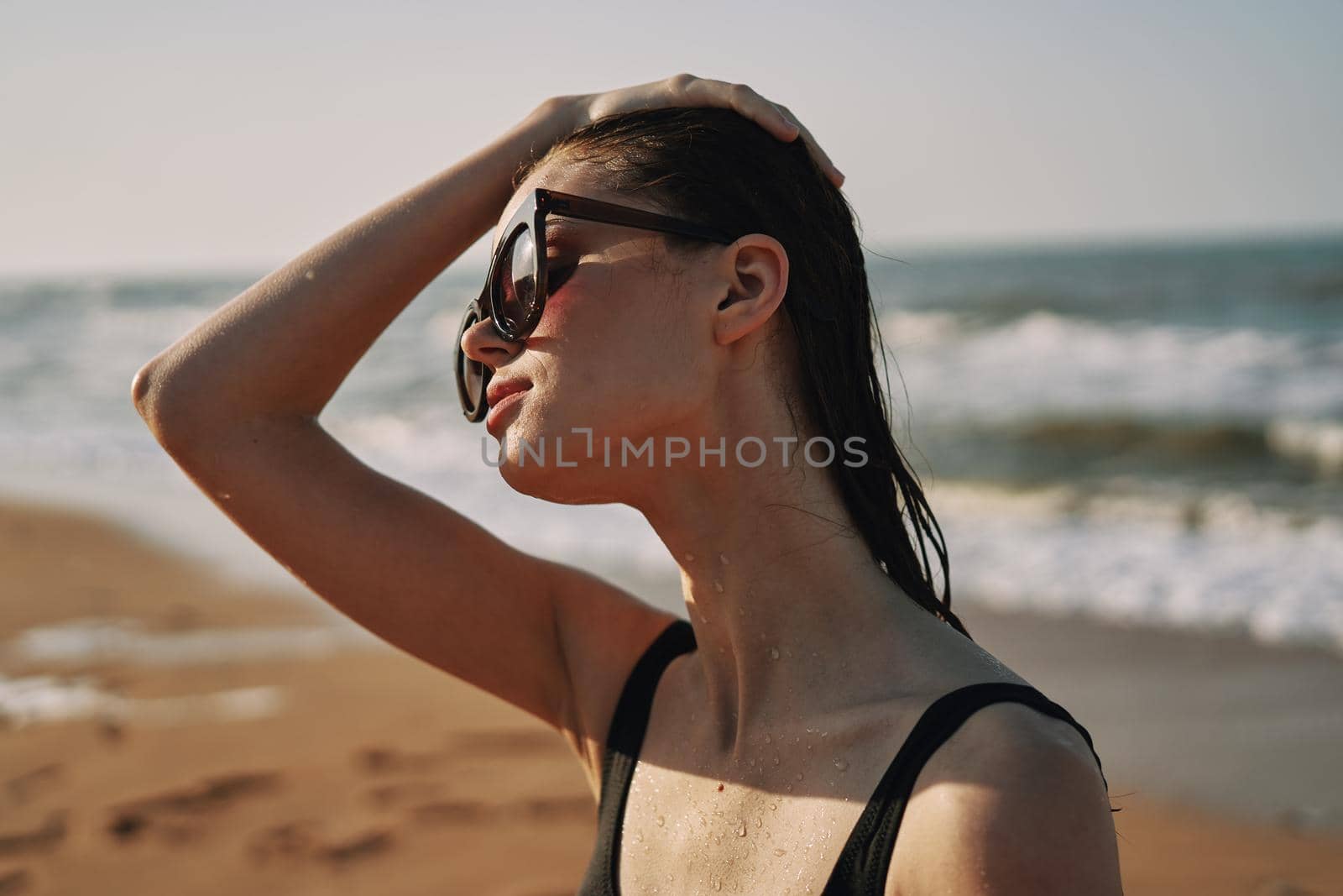 Cheerful woman black swimsuit ocean nature summer tan. High quality photo