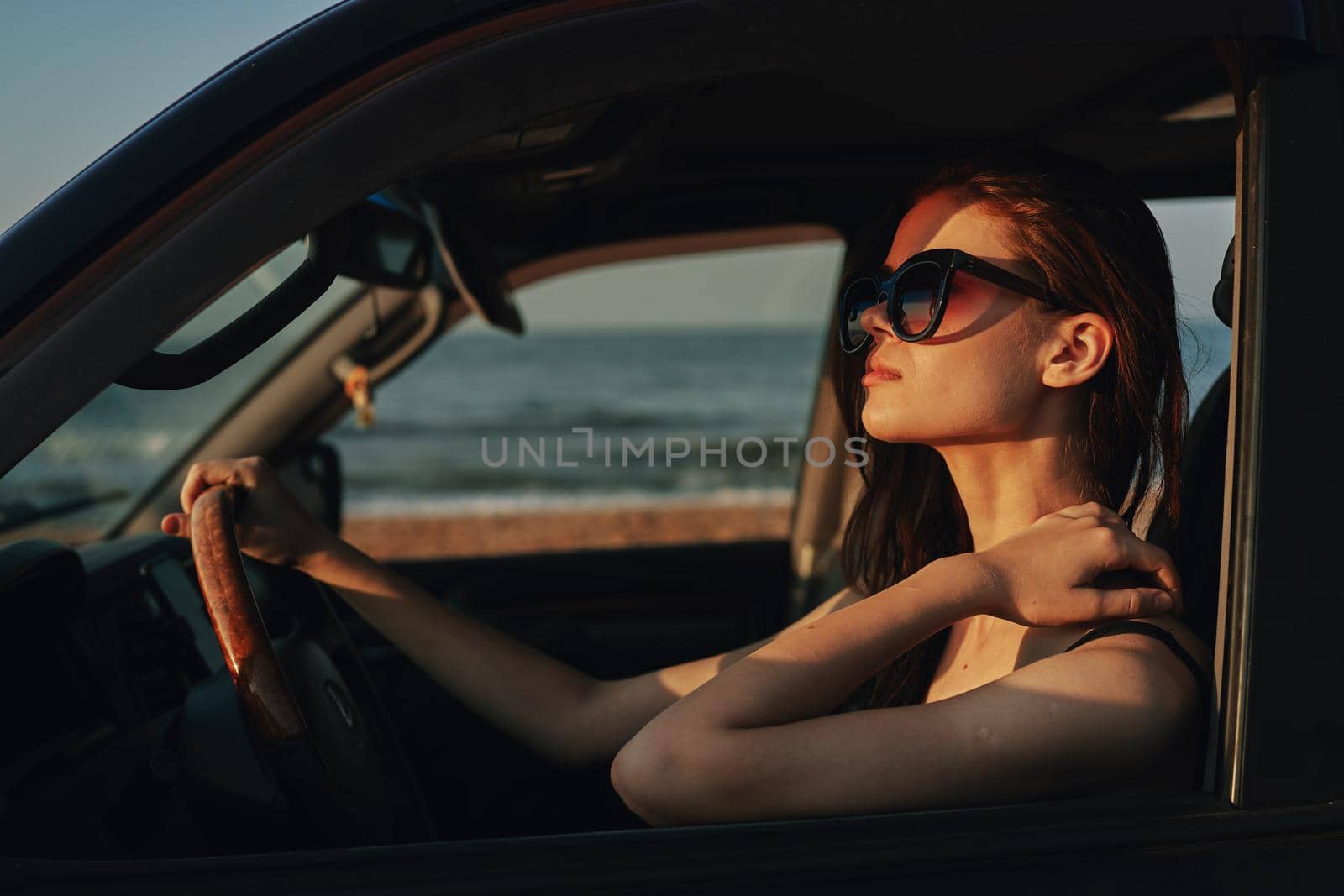 cheerful woman in sunglasses driving a car trip travel. High quality photo