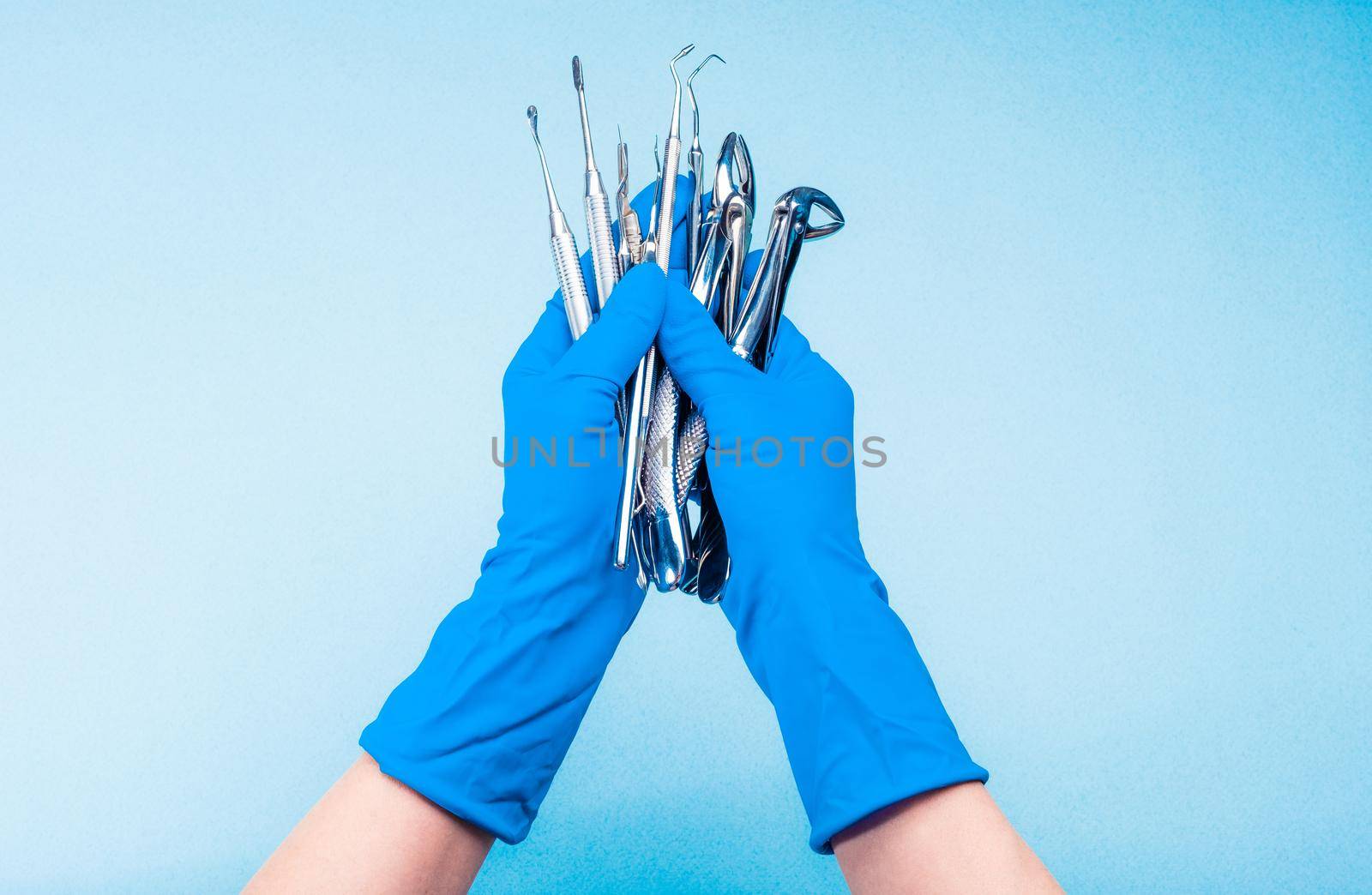 Hand in blue glove holding surgery dental tools by GekaSkr