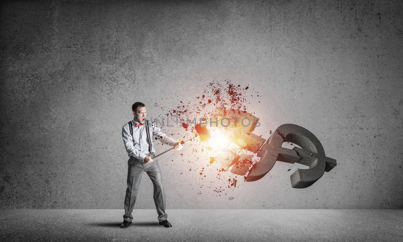Young furious businessman going to crash with hammer stone dollar symbol