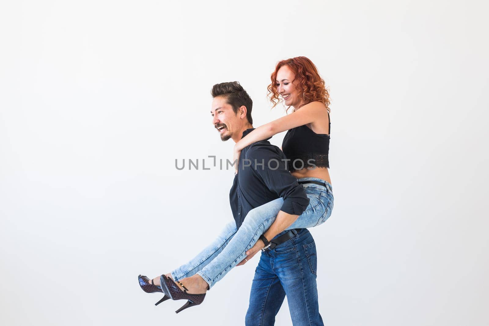 Friendship, people concept - young woman jumped on the man's back.