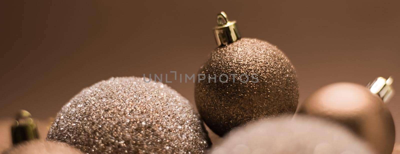 Christmas holiday and festive decoration concept. Golden baubles on beige background by Anneleven