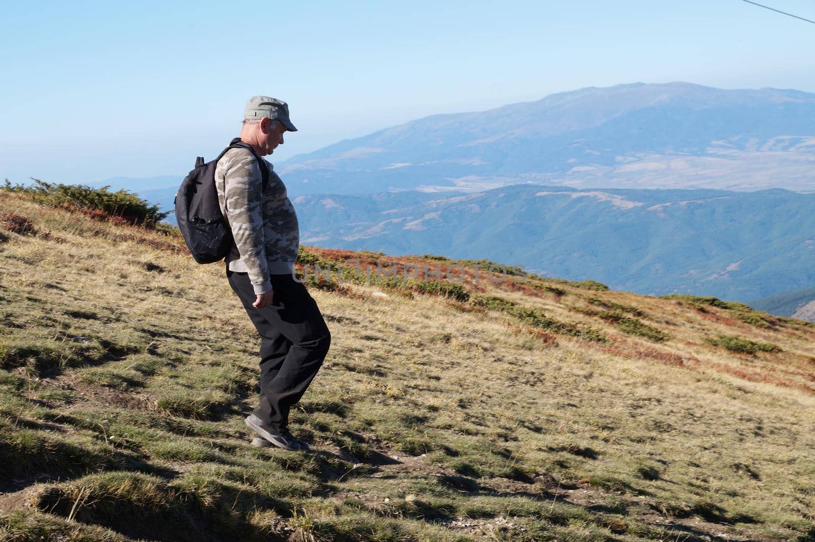 a man with a backpack goes to the mountains, side view