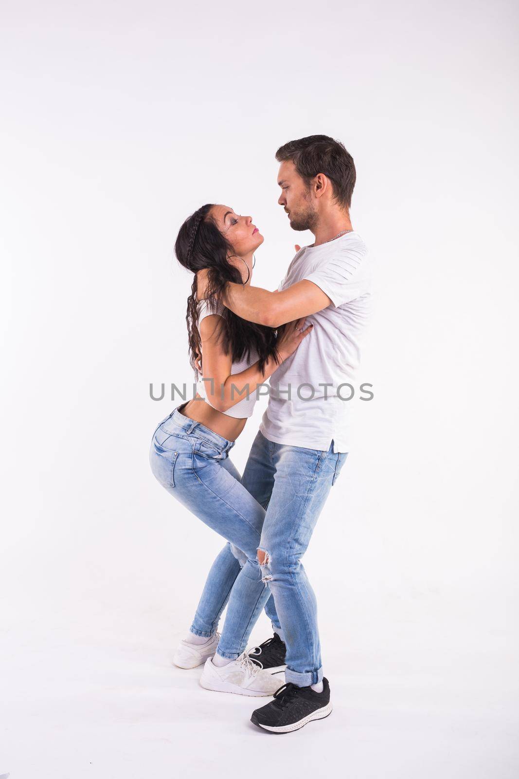 Young couple dancing social dance bachata, merengue, salsa, kizomba. Two elegance pose on white room. by Satura86