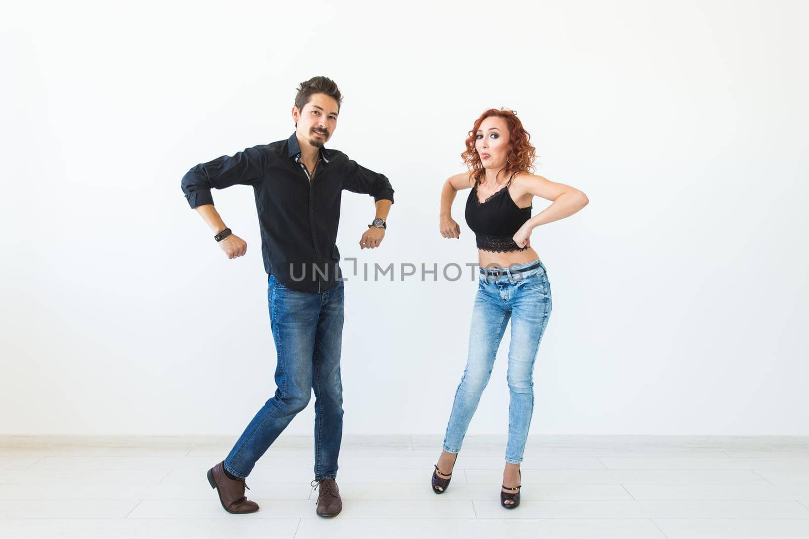 Social dance concept - Crazy dancing, cheerful couple over white background.
