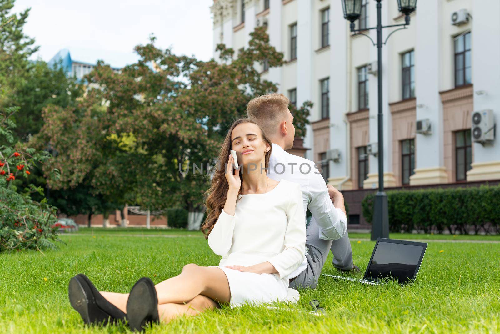 young attractive woman in the park. talking on the phone and smiling.