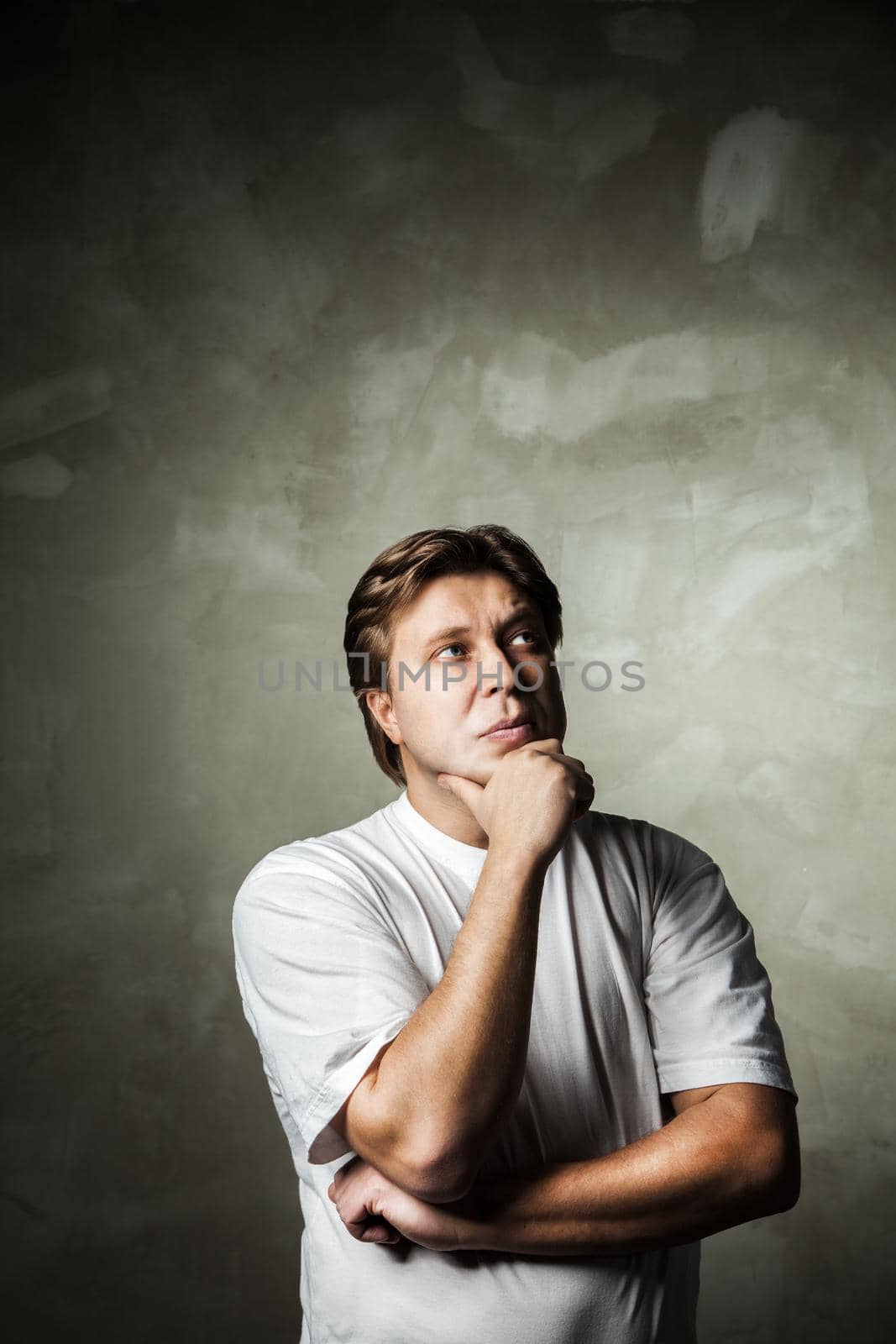 young handsome man doubting over gray background