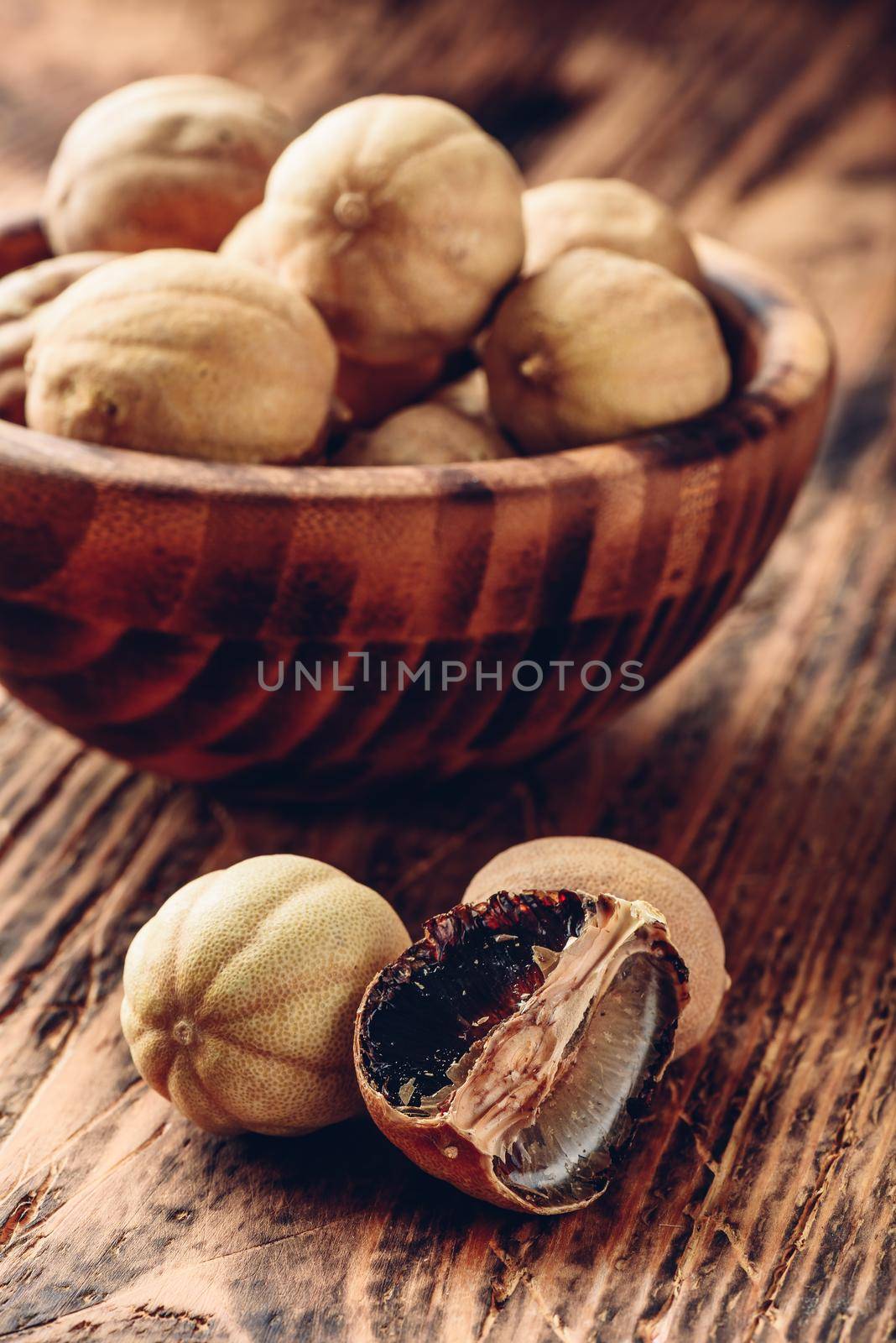 Dried limes on wooden table. Whole and crushed fruit