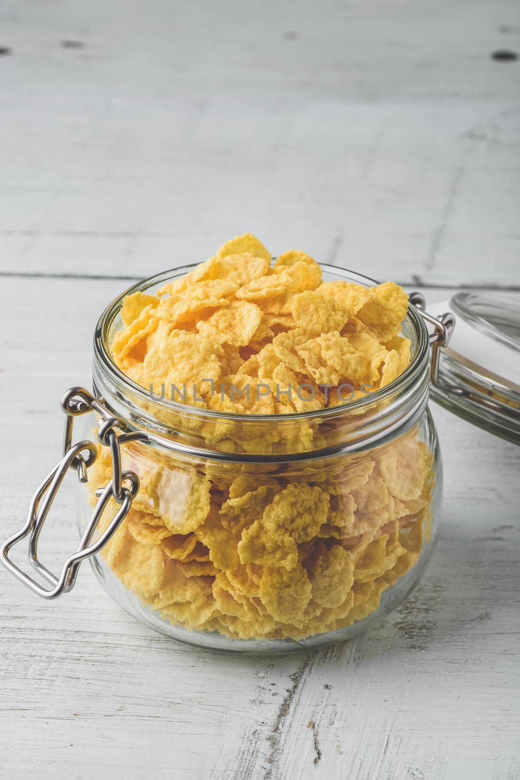 Corn flakes in a glass jar on wooden surface