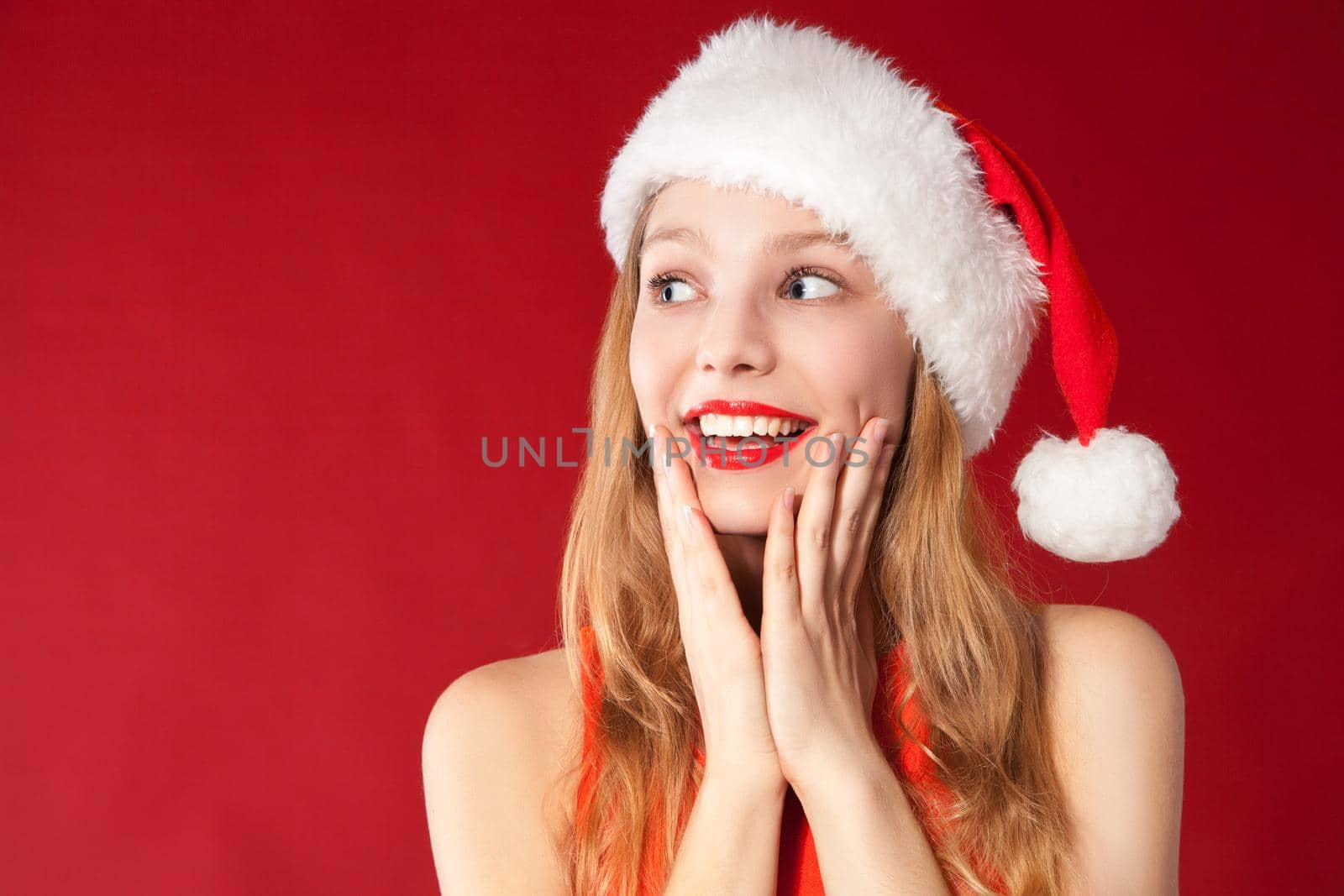 Portrait of beautiful sexy girl wearing santa claus clothes over red background