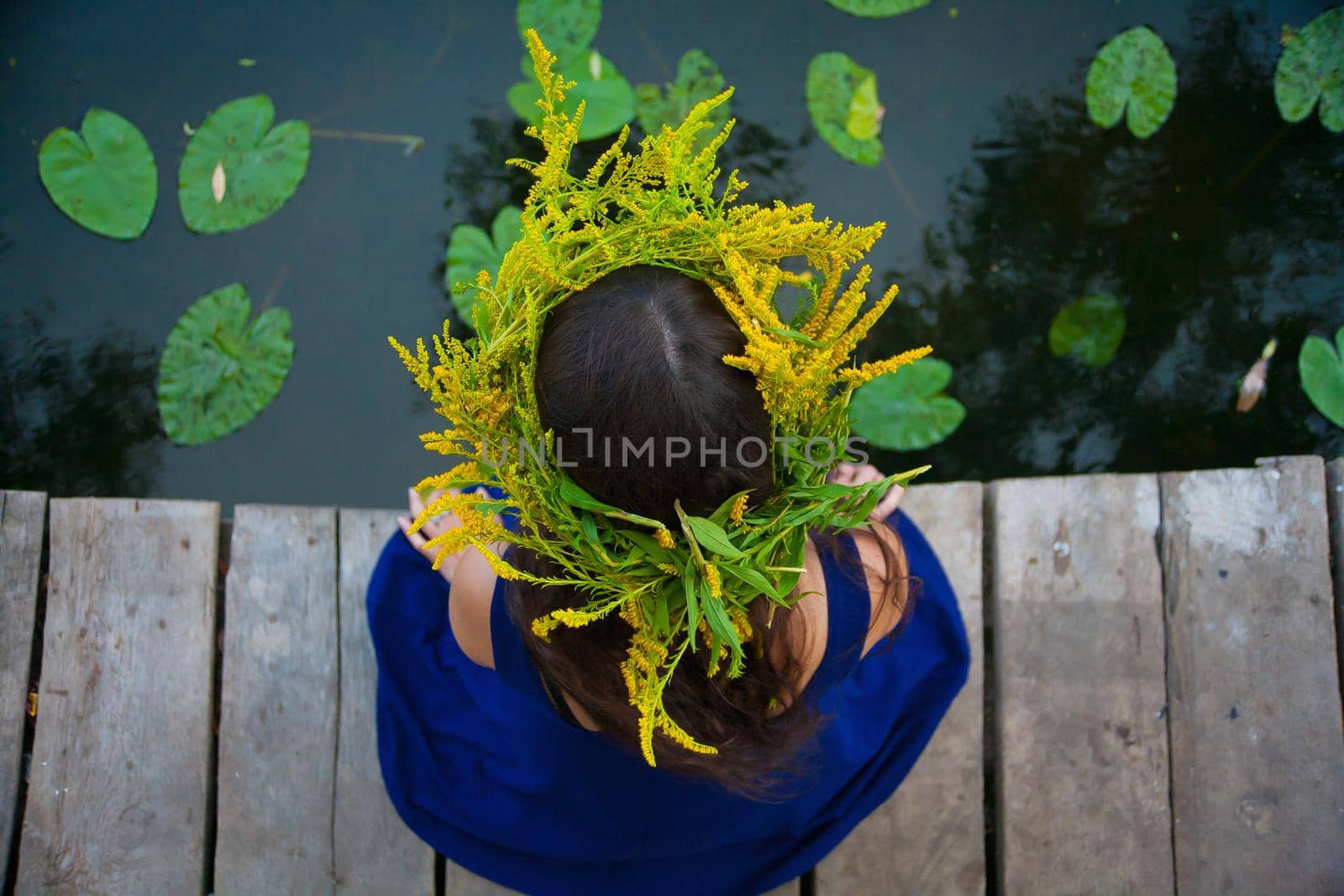 girl by the lake with a wreath on head.