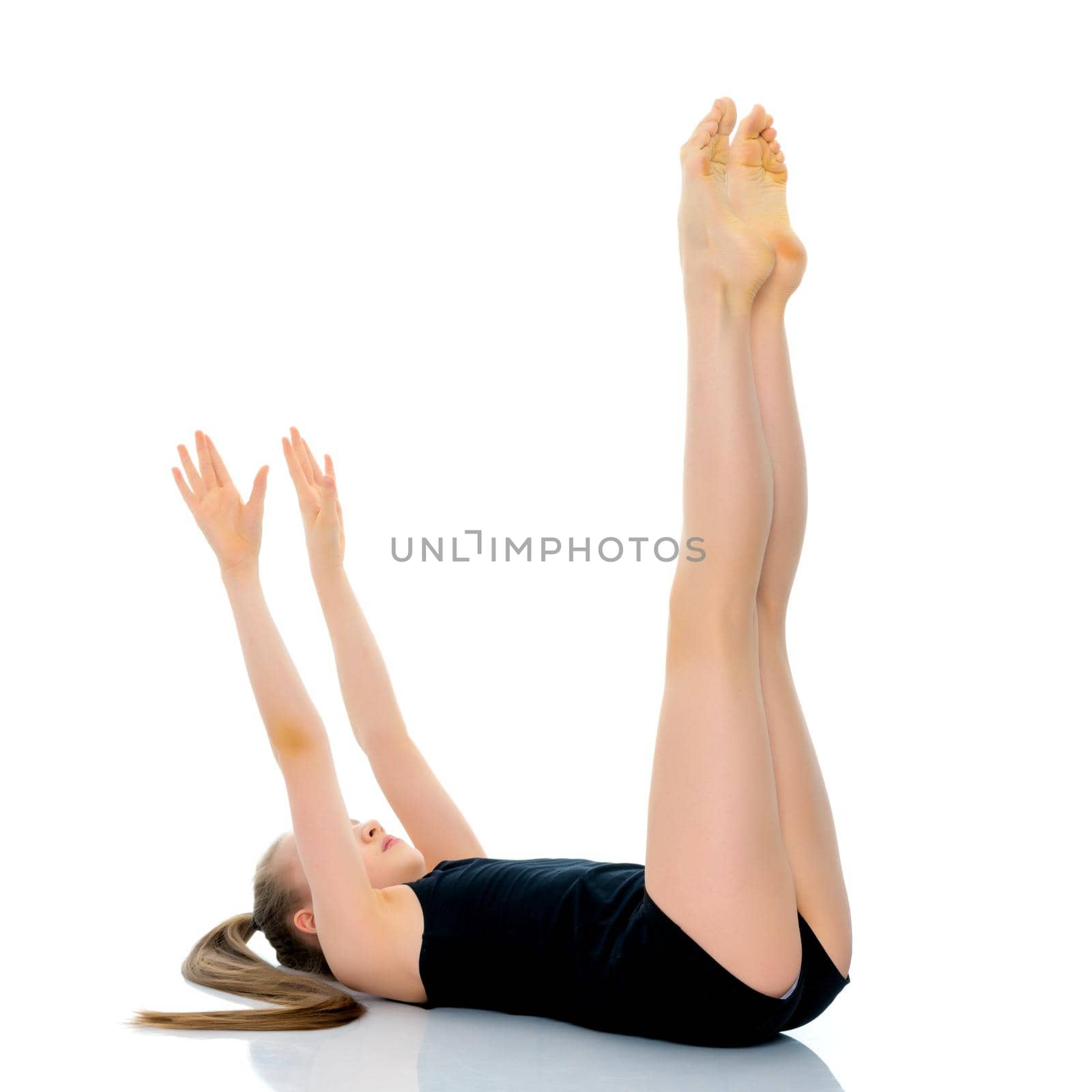 A girl gymnast performs an acrobatic element on the floor. The concept of childhood, sport, healthy lifestyle. Isolated on white background.