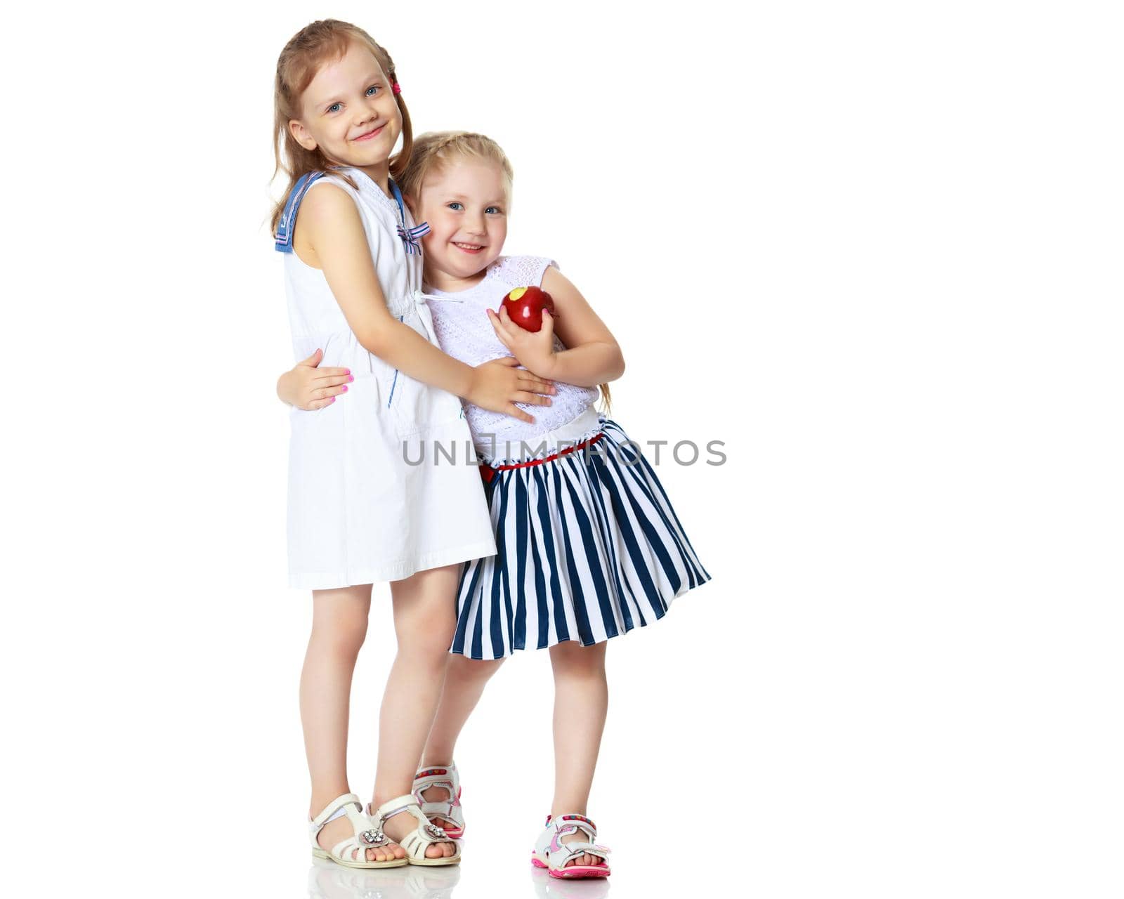 Two cute little girls in full growth, in the studio on a white background. The concept of a happy childhood, Beauty and fashion. Isolated.