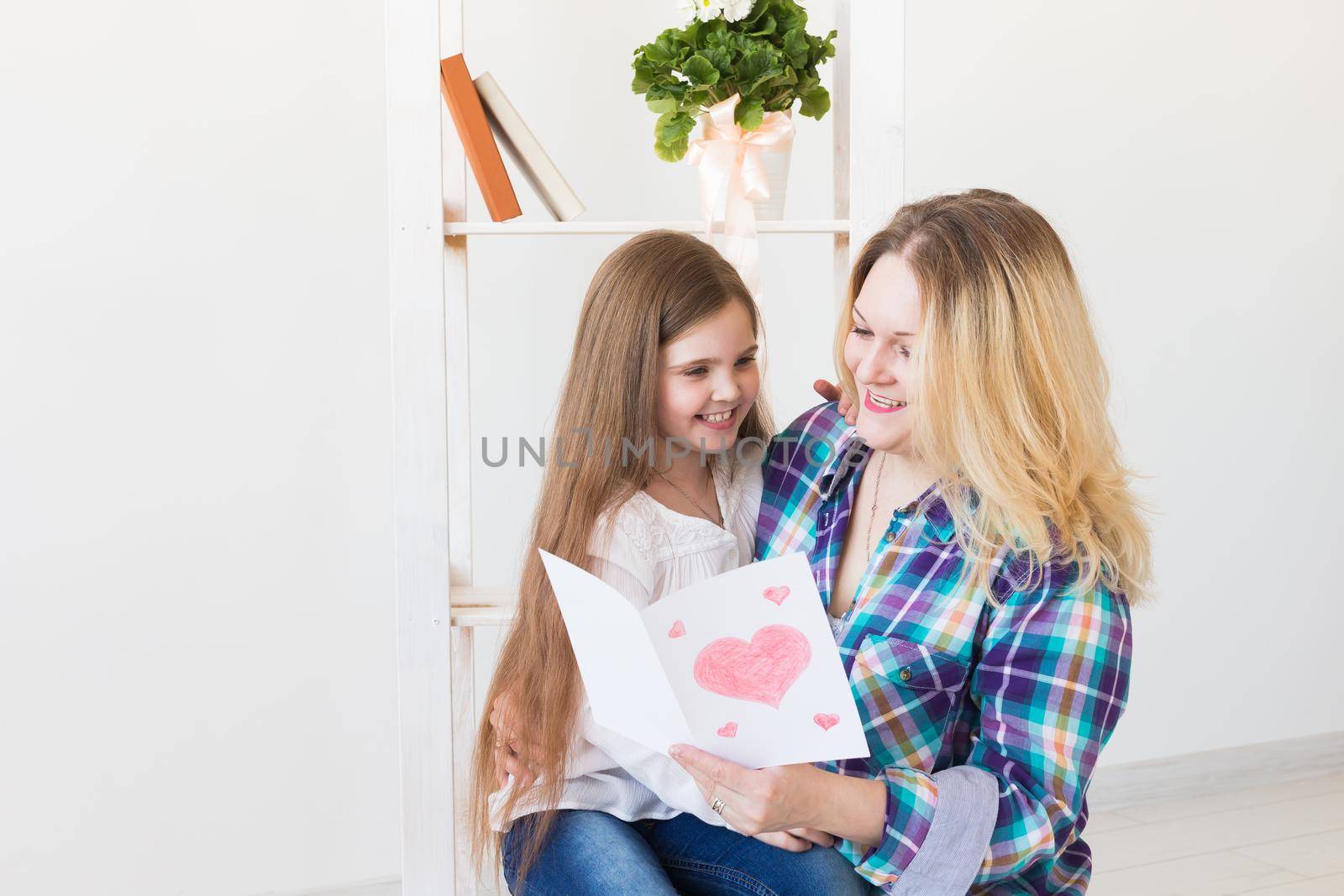 Mother's Day and family holidays - Mother reading greeting card from daughter.