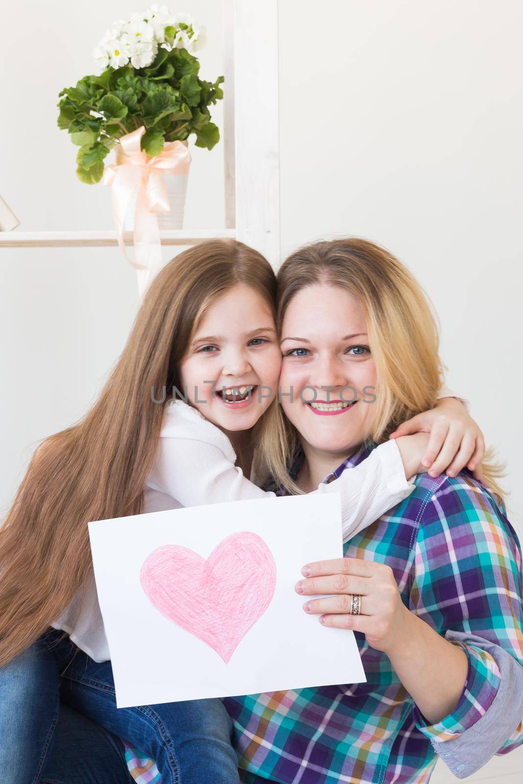 Mother's Day and family holidays - Mother reading greeting card from daughter.