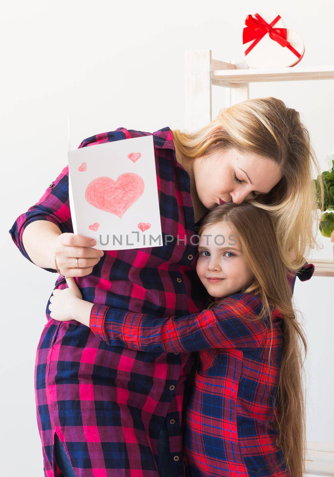 Mother's Day and family holidays - Mother reading greeting card from daughter.